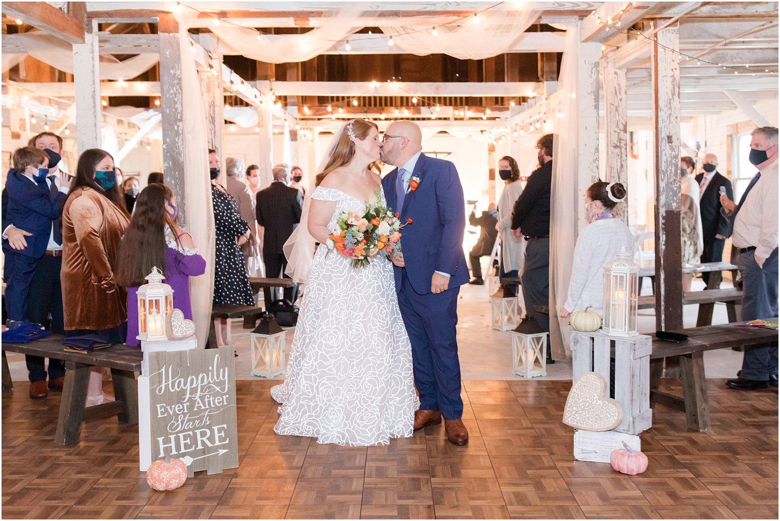 bride and groom kiss at the end of the aisle