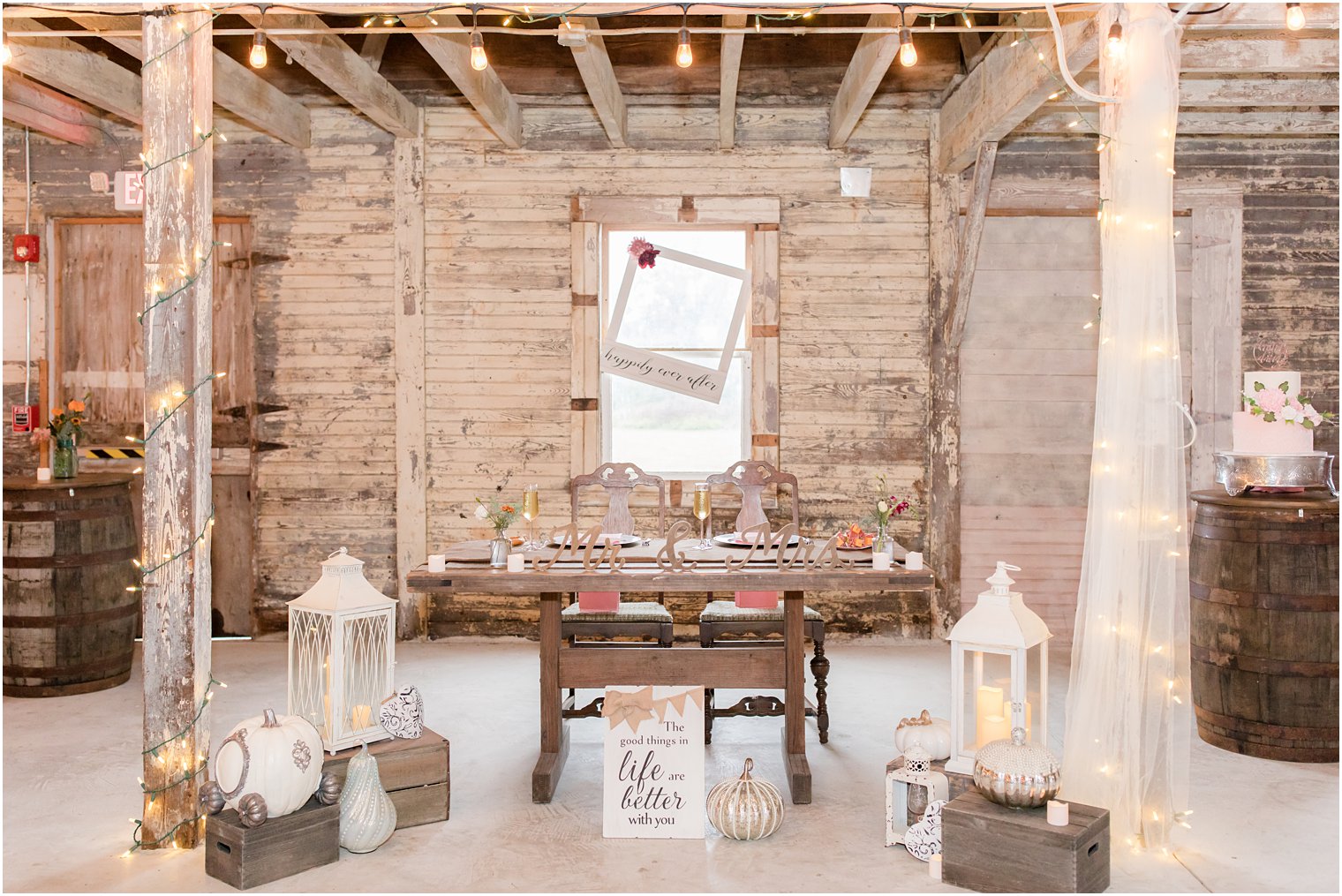 rustic fall wedding reception sweetheart table with lanterns and pumpkins