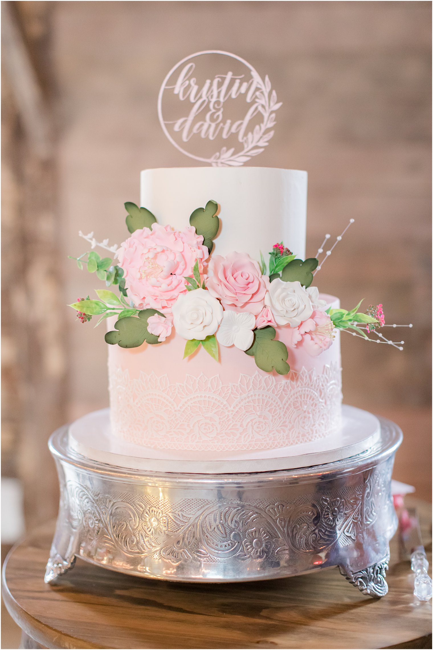 tiered wedding cake with ink and ivory flowers