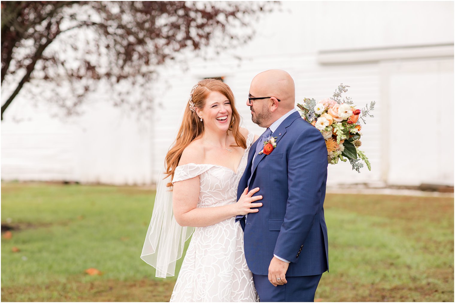 newlyweds laugh together during fall wedding portraits at Eagle Manor