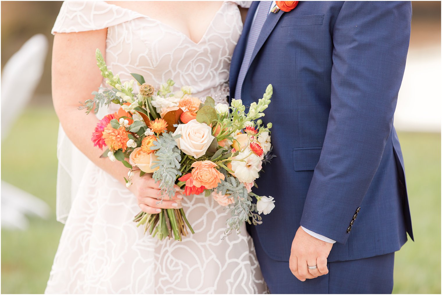 bride holds fall wedding bouquet while hugging groom