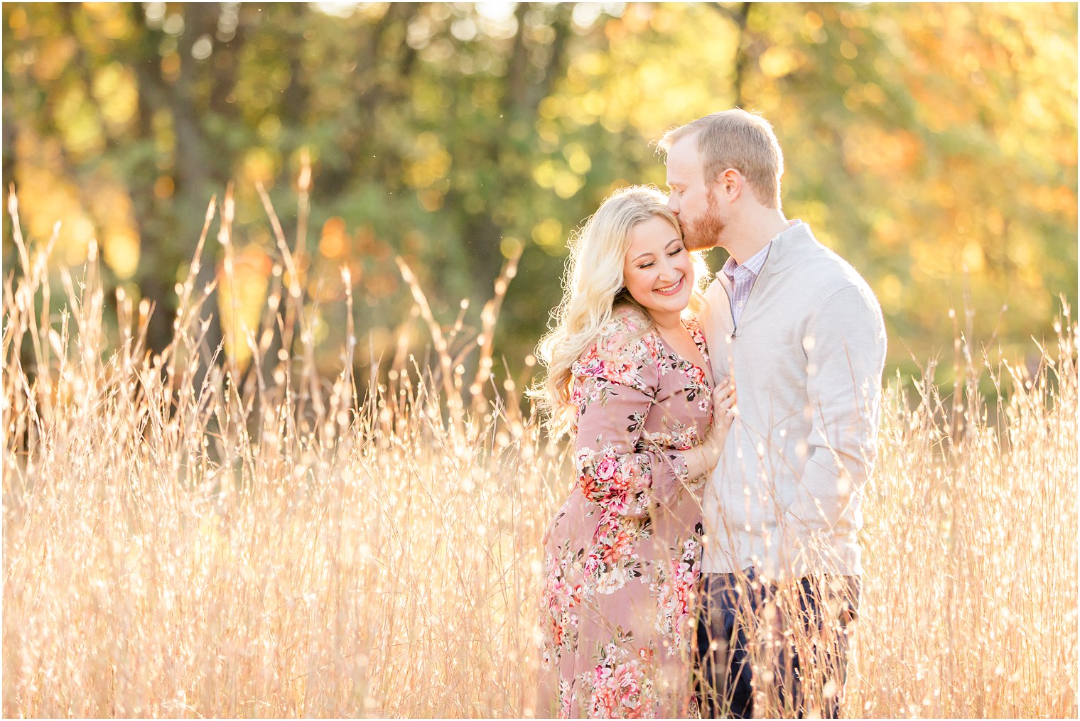 groom kisses bride's temple standing in field at Ramapo Reservation