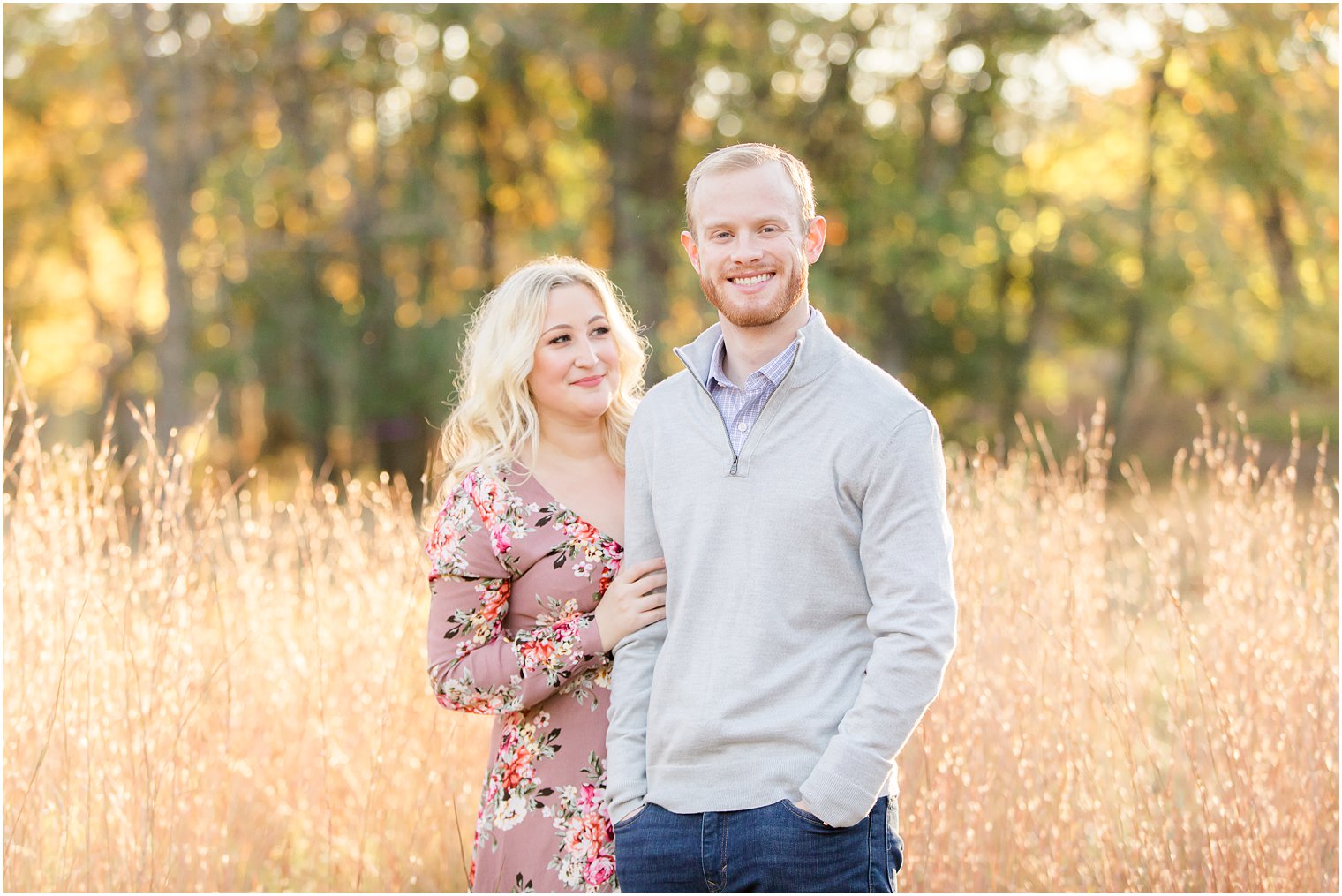 bride holds onto groom's arm during NJ engagement photos