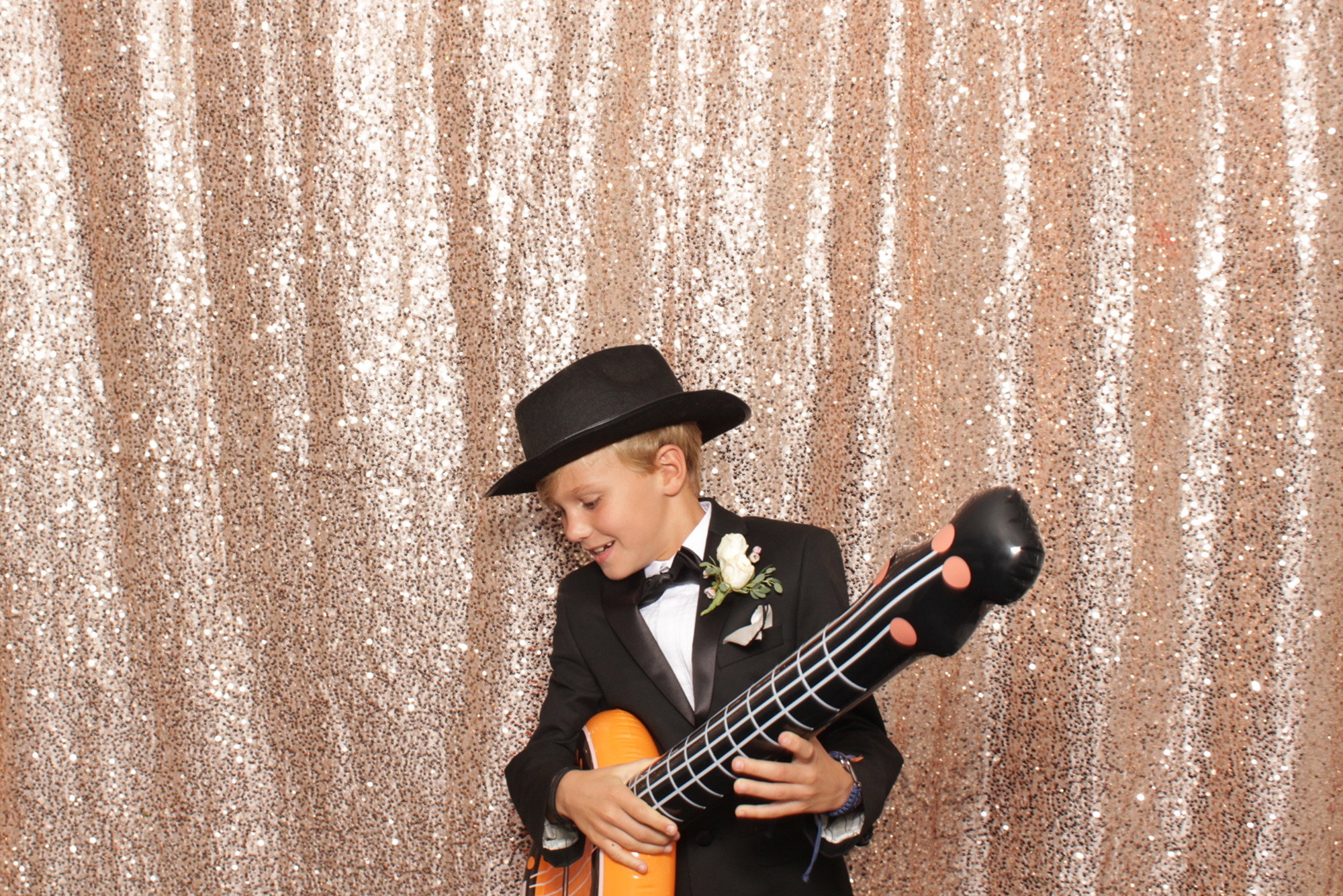 kid plays inflatable guitar during photo booth fun