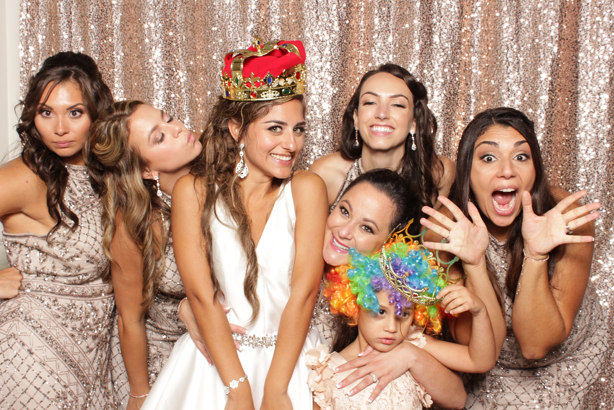 bride poses with bridesmaids in photo booth