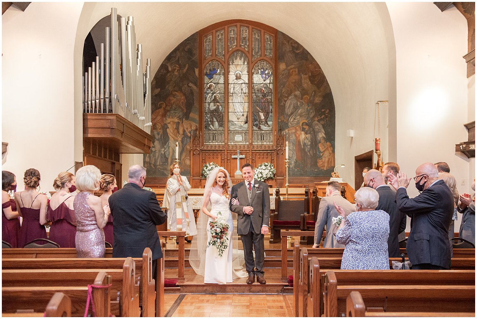 bride and groom look at guests after traditional church wedding ceremony at Grace Episcopal Church in Nutley