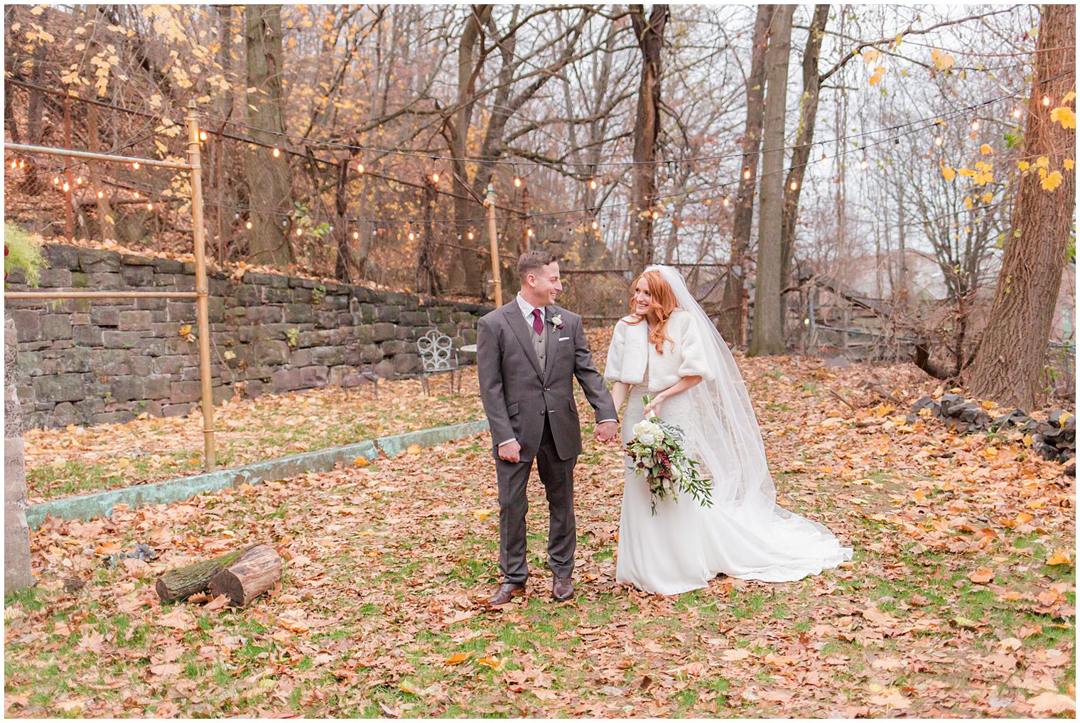 bride and groom walk in the leaves outside Art Factory Studios