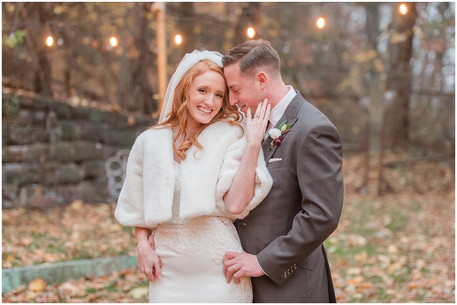 bride holds groom's cheek during NJ wedding portraits in the winter