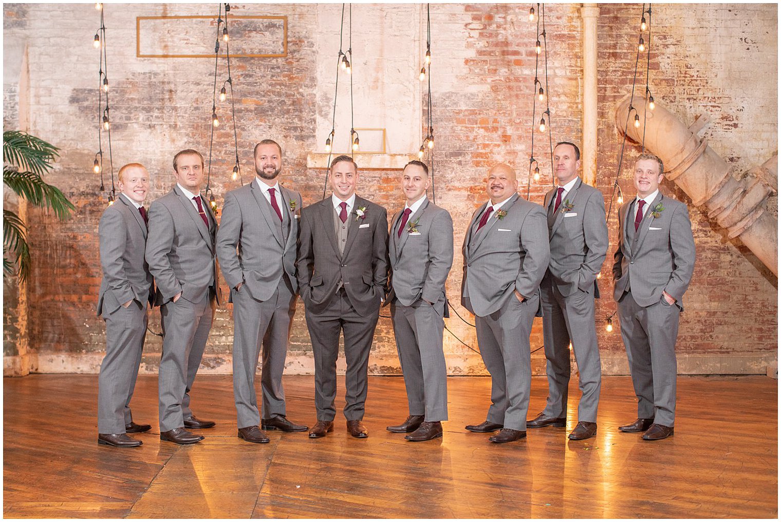 groom and groomsmen pose in grey suits during Art Factory Studios wedding photos