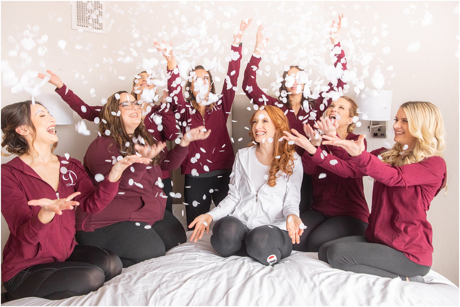 bride and bridesmaids toss confetti while preparing for NJ wedding