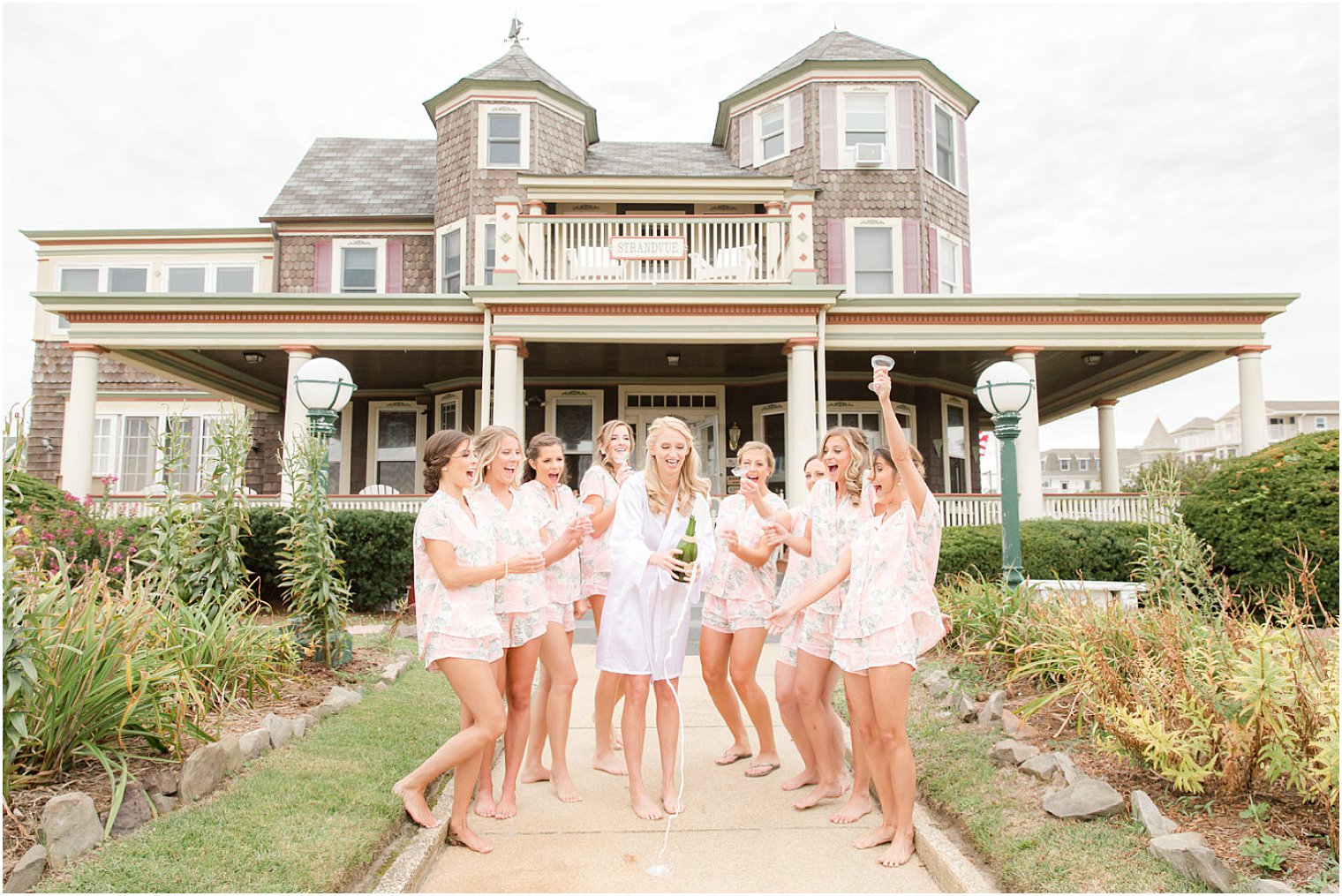 bride and bridesmaids popping champagne at Airbnb in Ocean Grove NJ