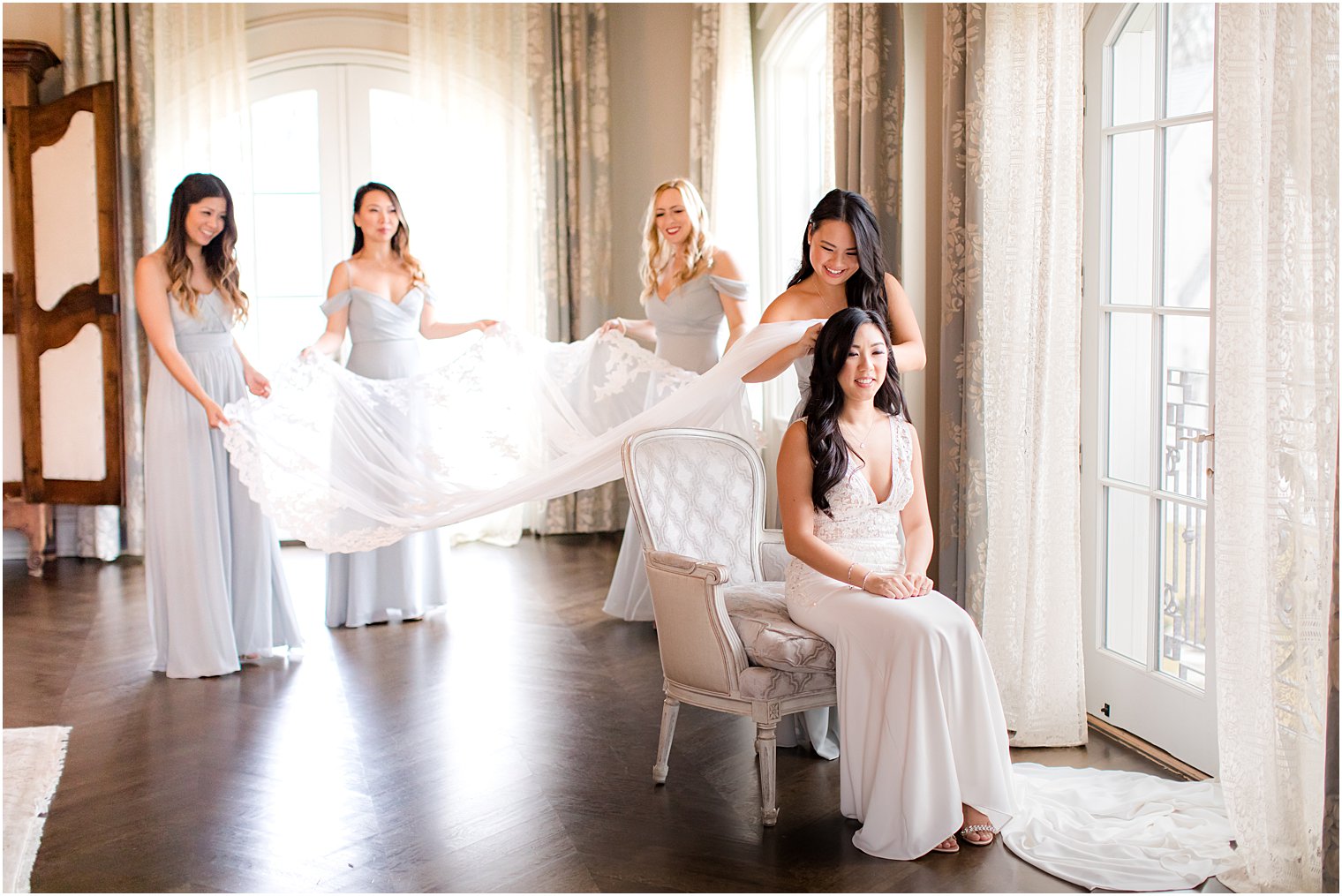 Bridesmaids putting on bride's veil at Park Chateau Estate