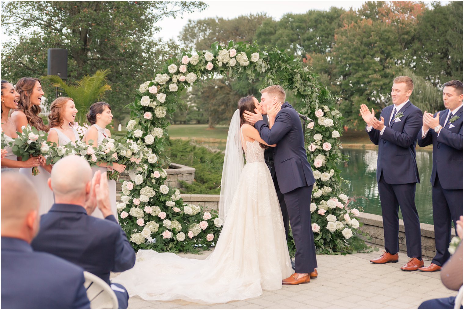 Bride and groom kissing in outdoor ceremony at Windows on the Water at Frogbridge