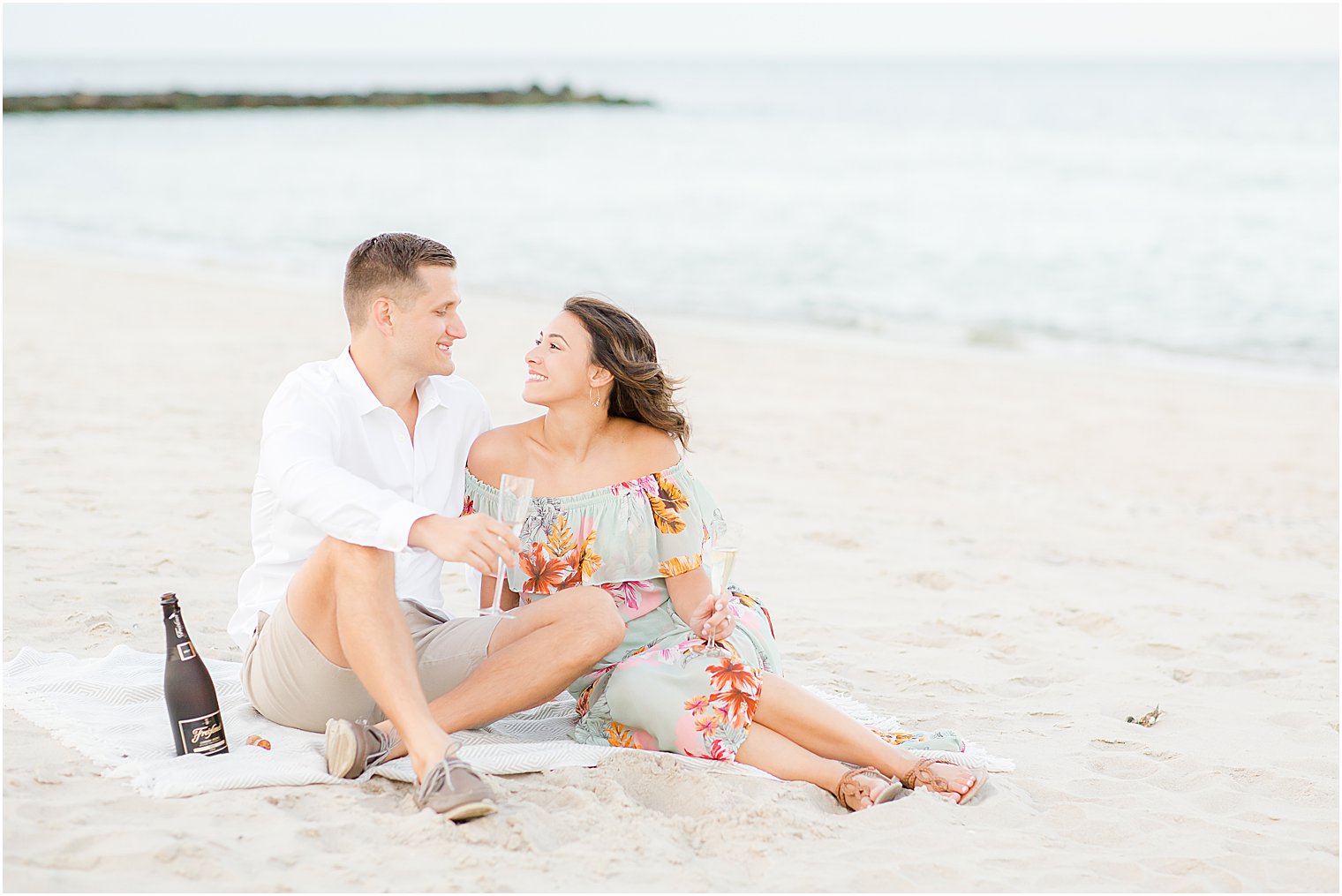 New Jersey couple sits on beach toasting champagne