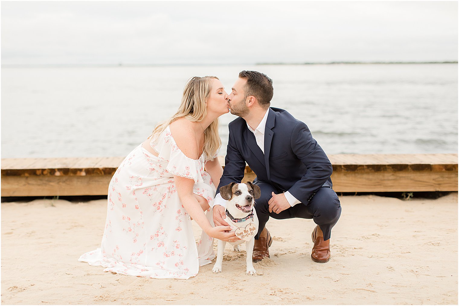 engaged couple kisses on New Jersey beach over dog