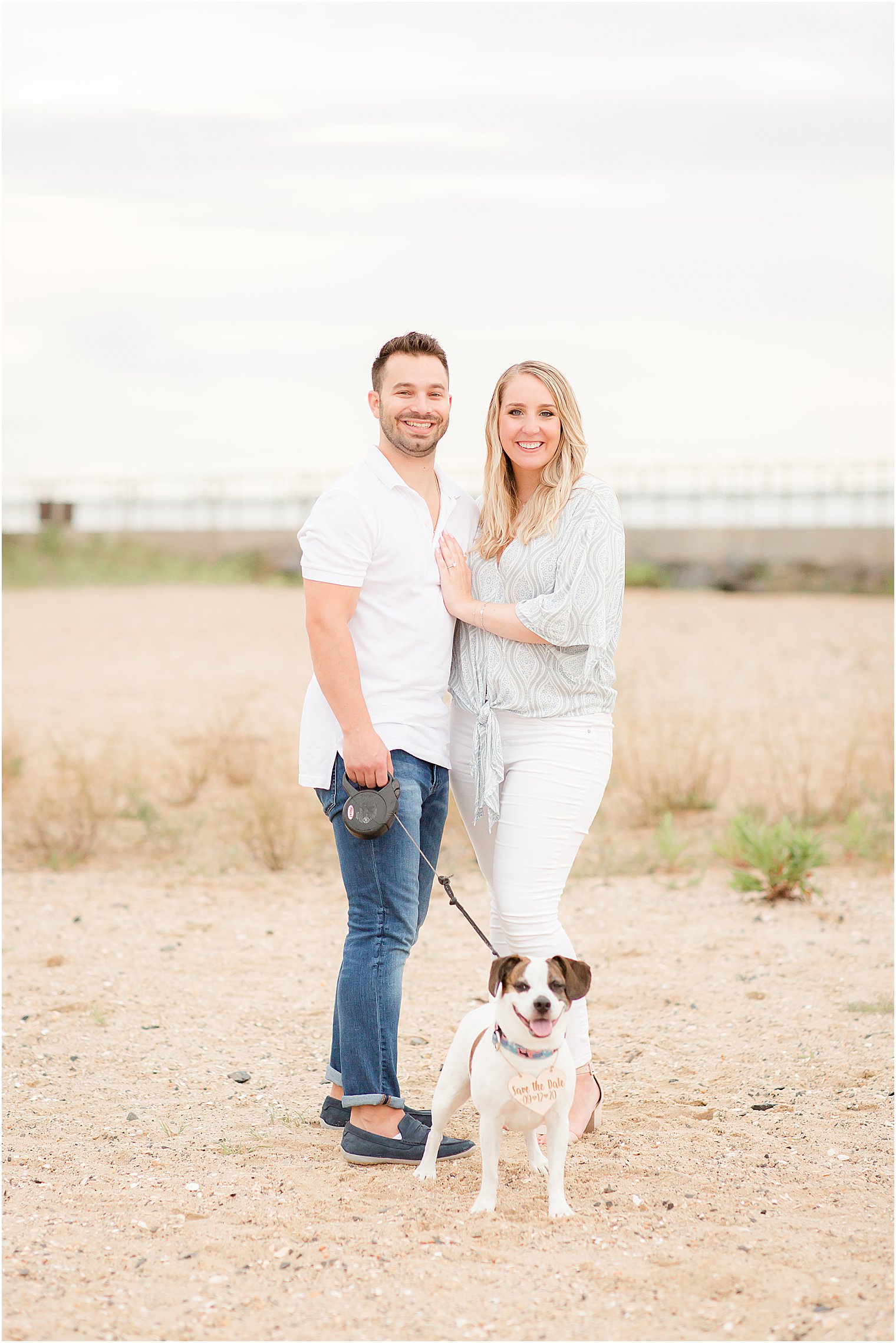 New Jersey couple stands with dog on leash during engagement photos