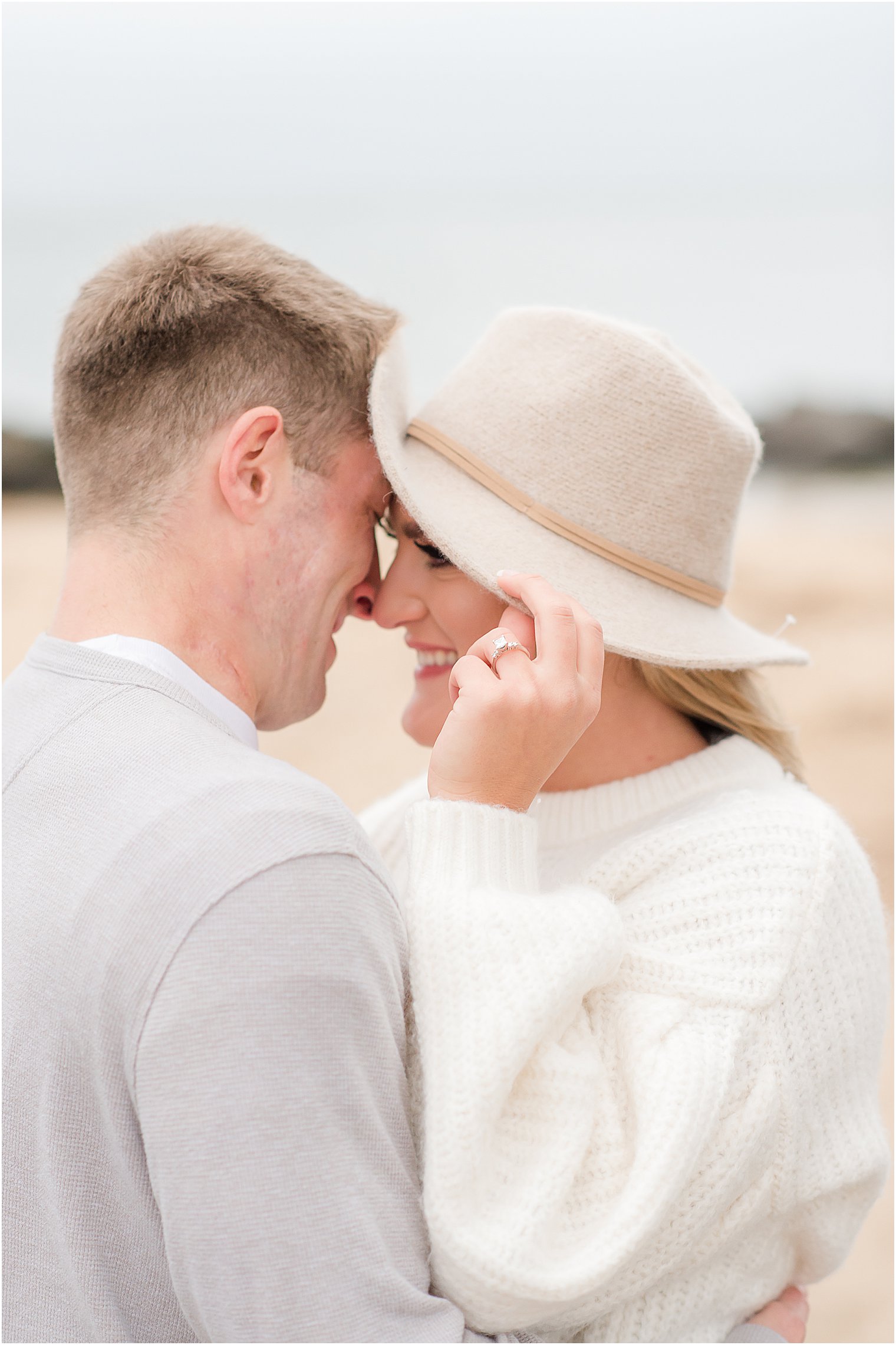 bride holds edge of her hat showing off engagement ring 