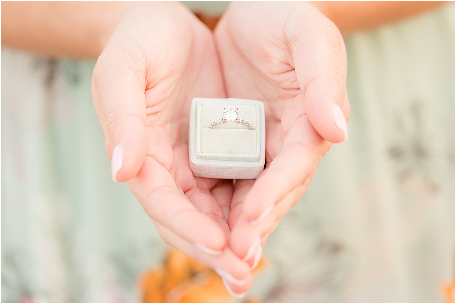 bride holds ring in teal ring box