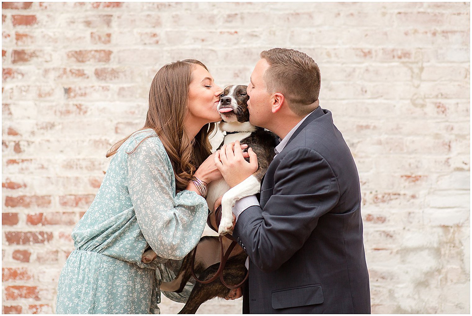 engaged couple kisses dog during portraits