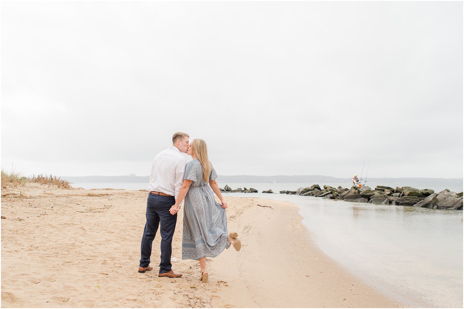bride pops foot while couple kisses on Sandy Hook Beach
