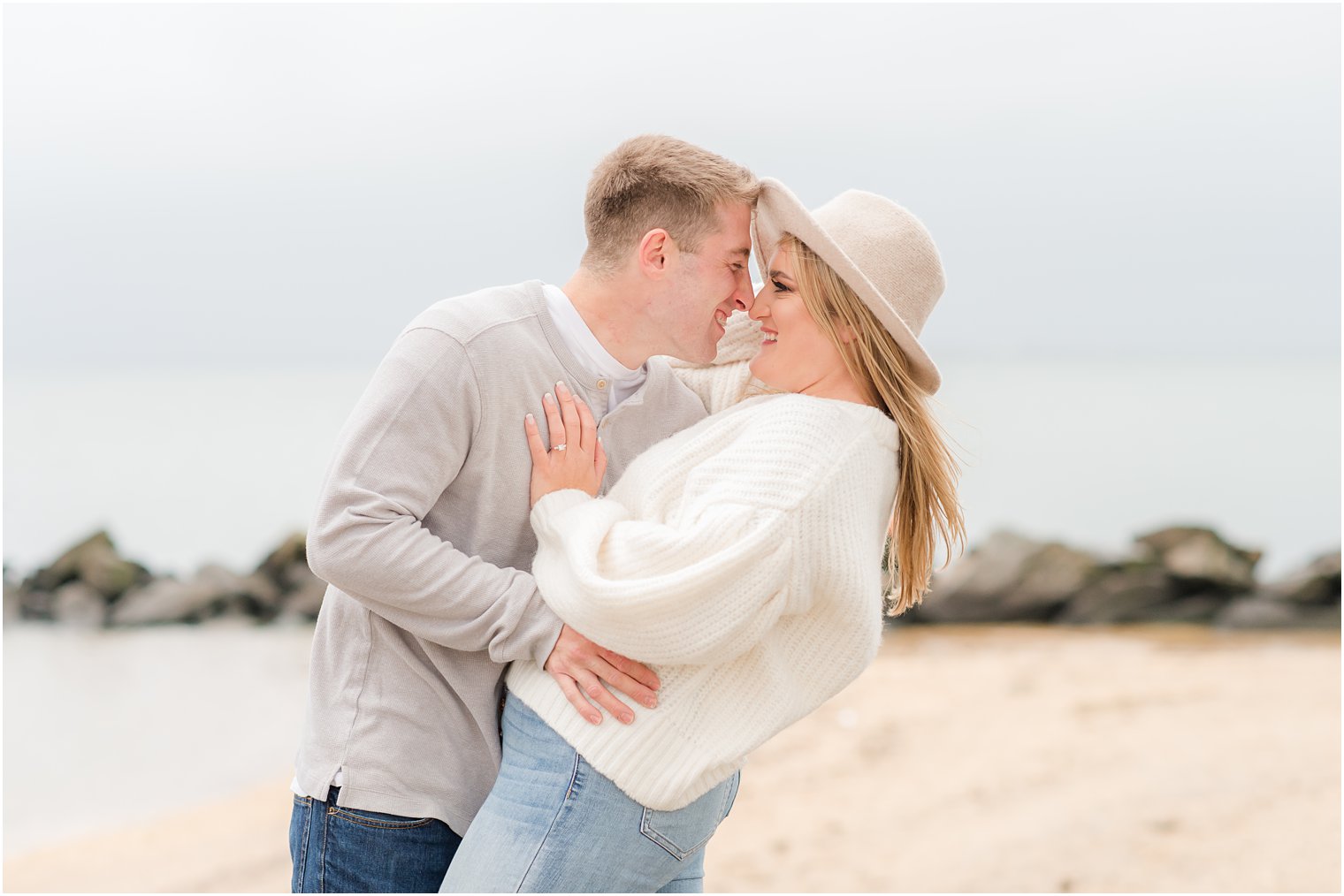 bride and groom nuzzle noses during engagement photos at Sandy Hook