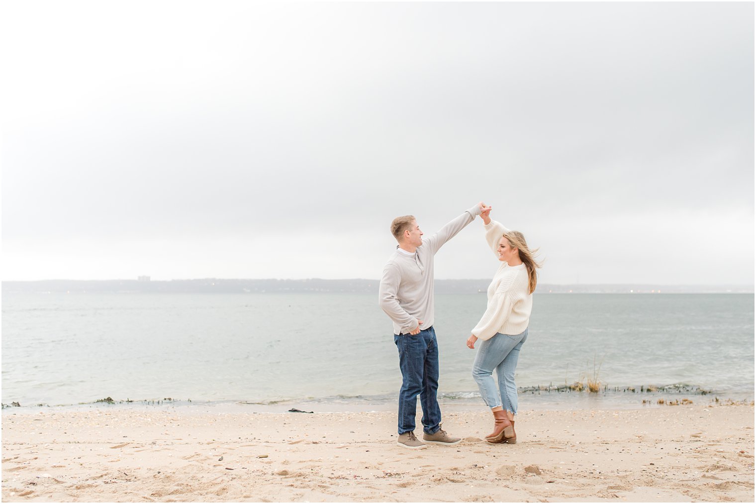 engaged couple dances on Sandy Hook Beach in New Jersey