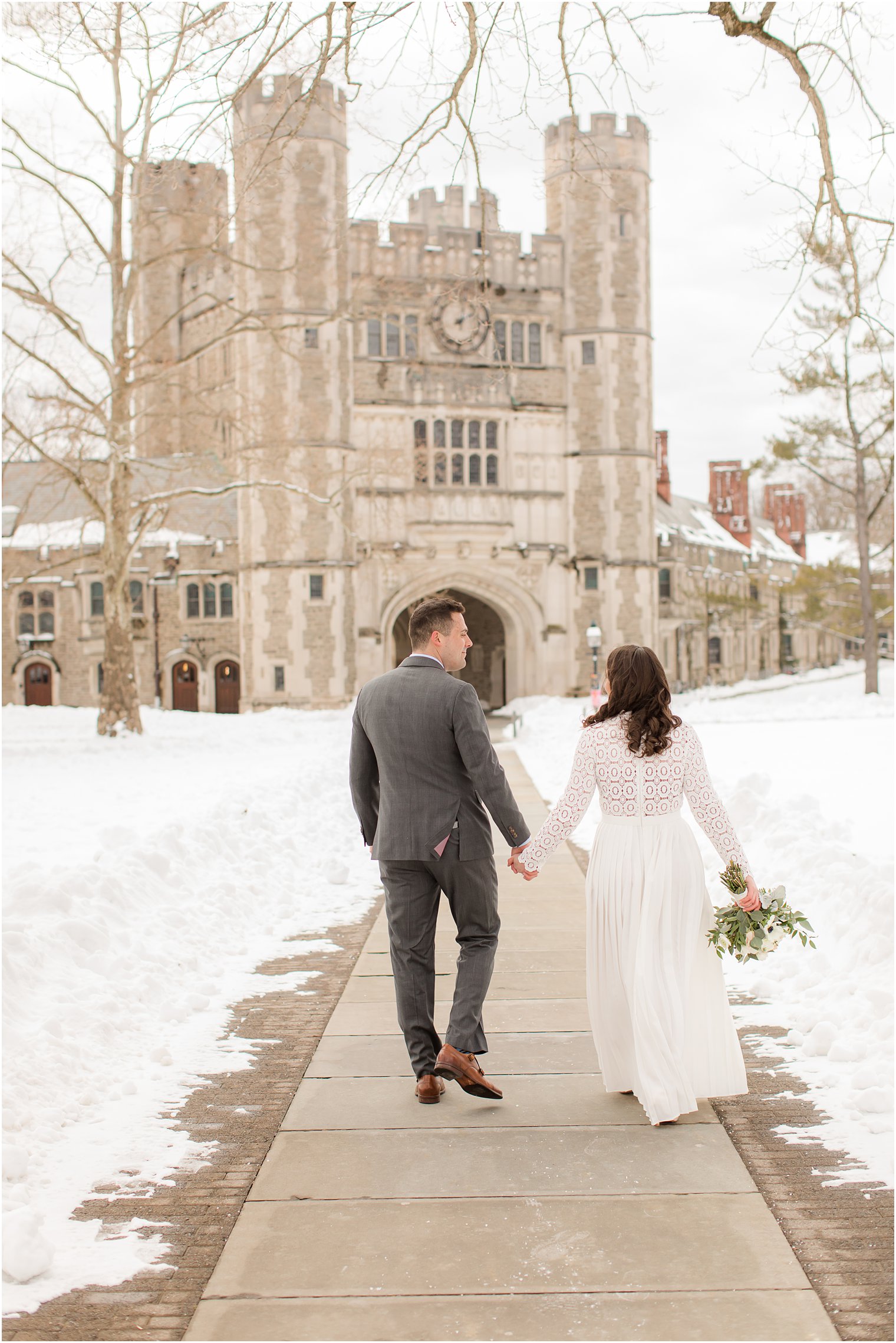 bride and groom walk towards building at Princeton University 