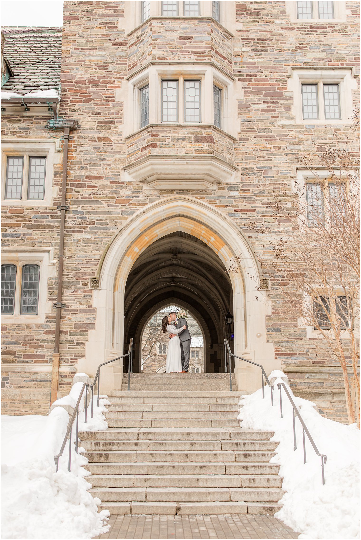bride and groom kiss under archway on Princeton University New Jersey campus 