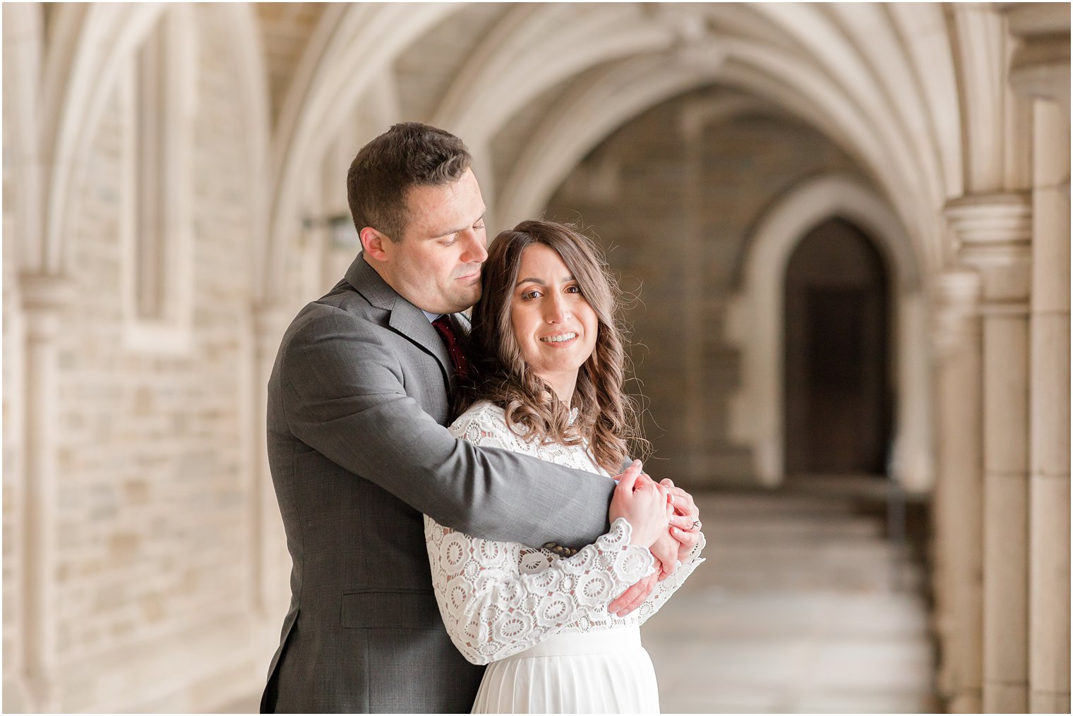 groom hugs bride from behind during New Jersey wedding portraits 