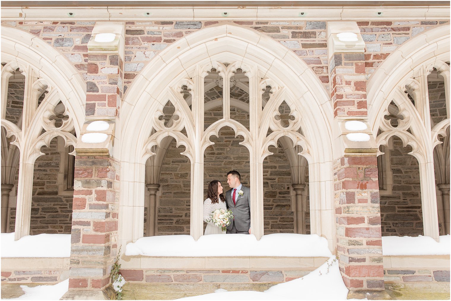bride and groom look at each other framed by windows at Princeton University 
