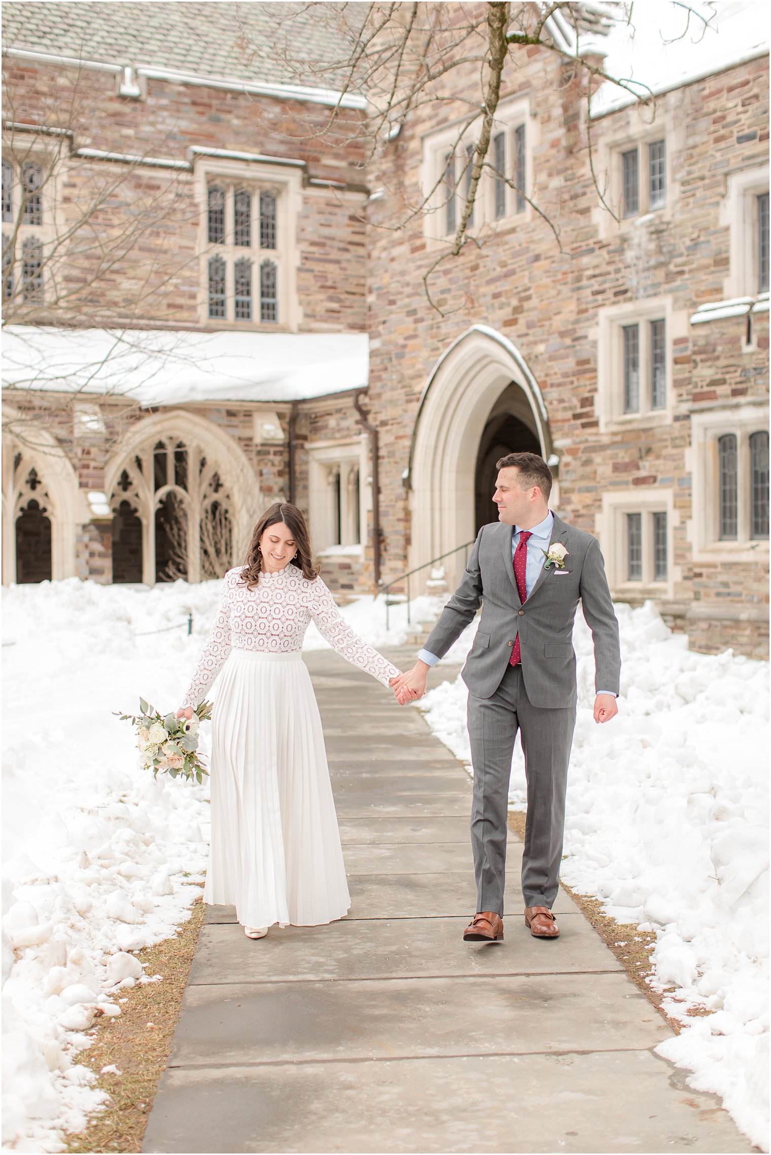bride and groom hold hands walking along sidewalk in Princeton NJ