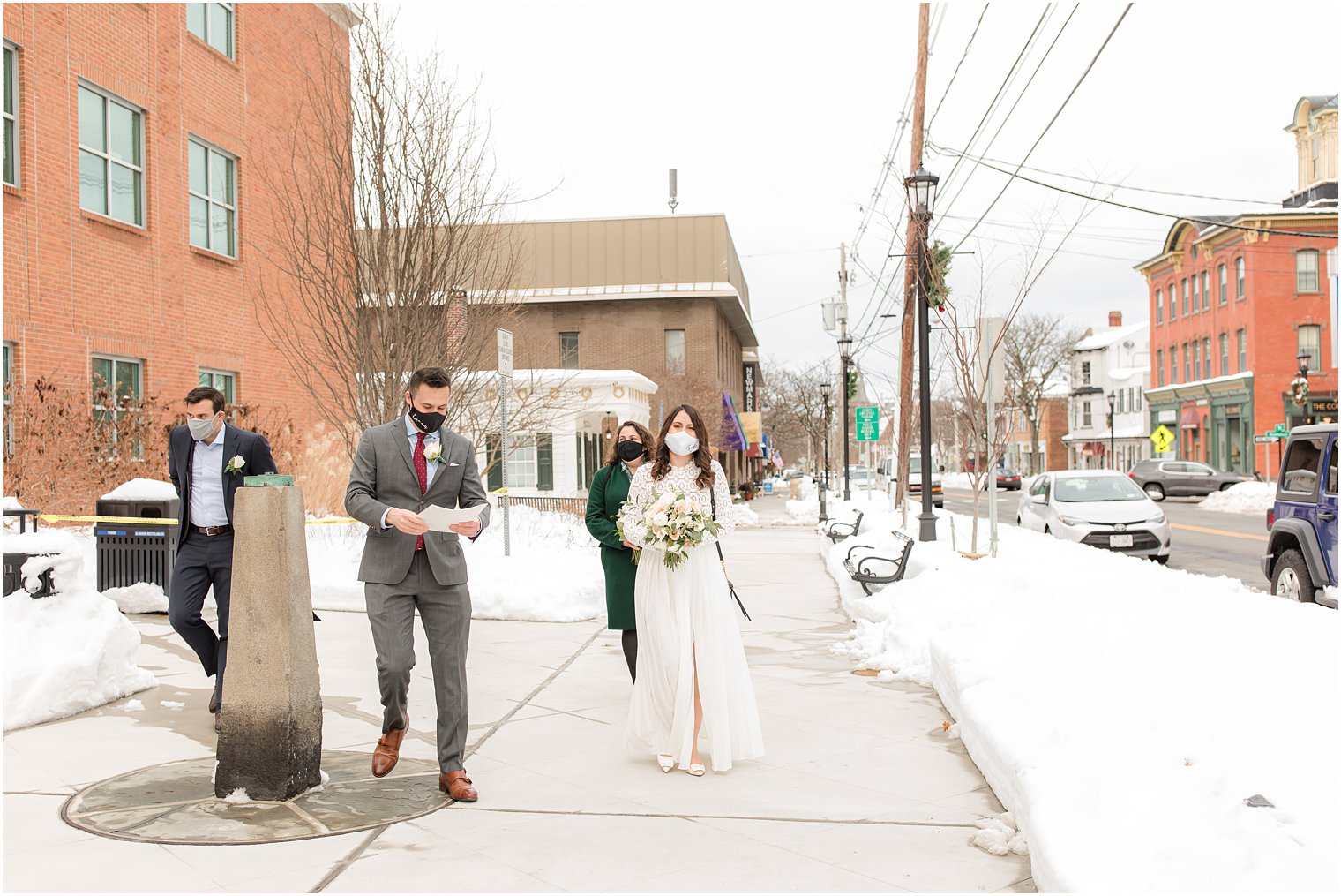 bride and groom walk with family into NJ courthouse 