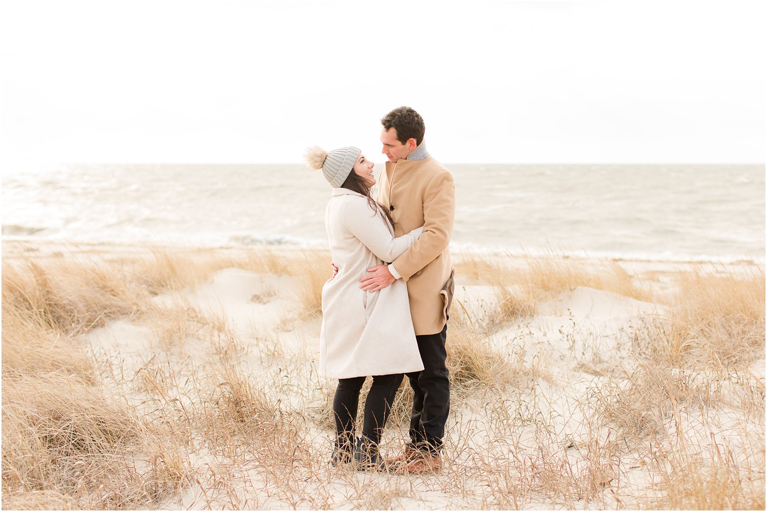 Engaged couple embracing on the beach in Cape May