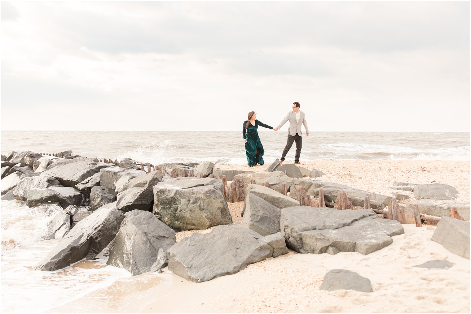 Engaged couple on a windy day at the beach