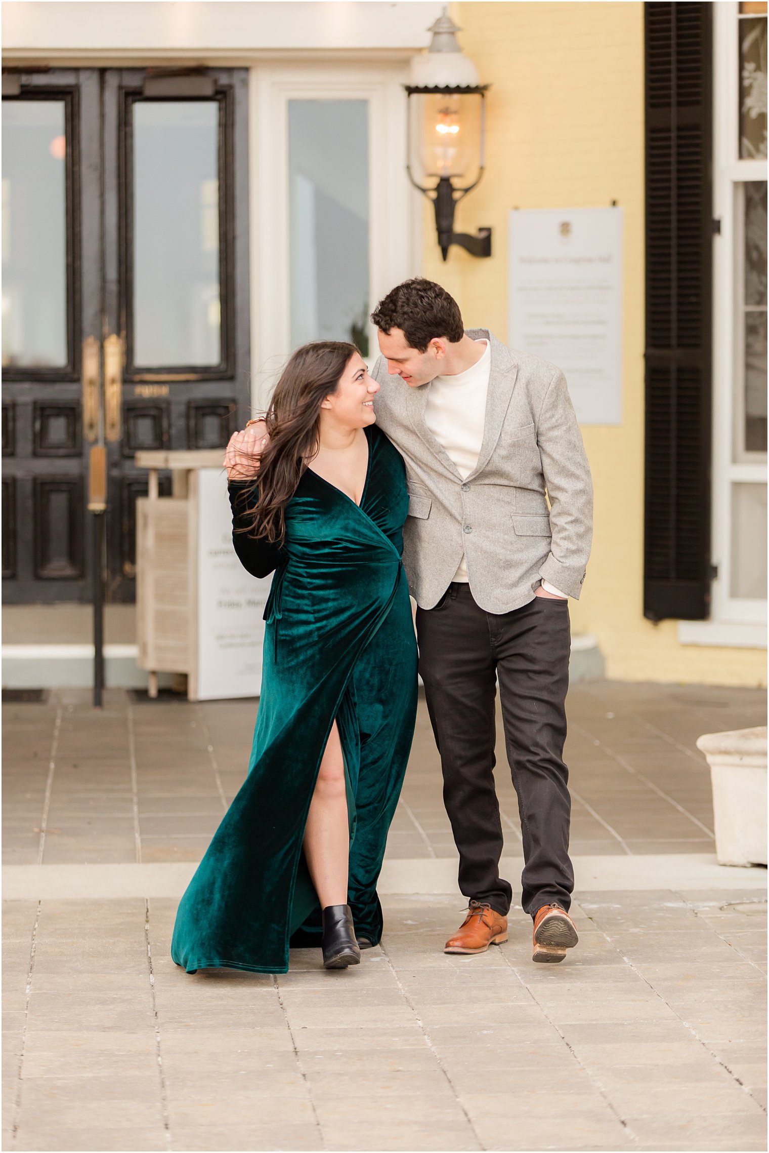 Engaged couple wearing dressy outfits on the patio of Congress Hall in Cape May, NJ