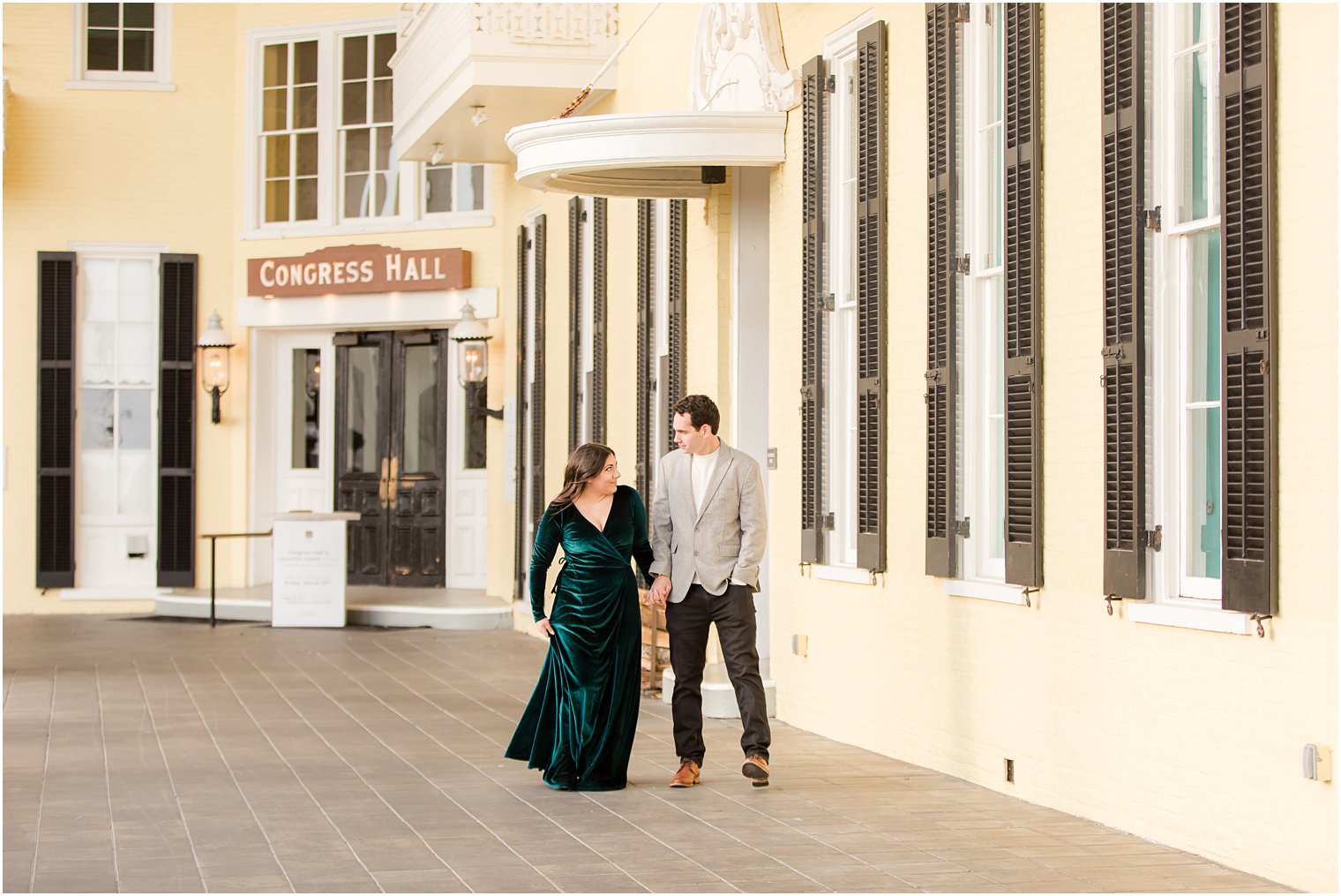 Couple walking in front of Congress Hall in Cape May for their engagement photos