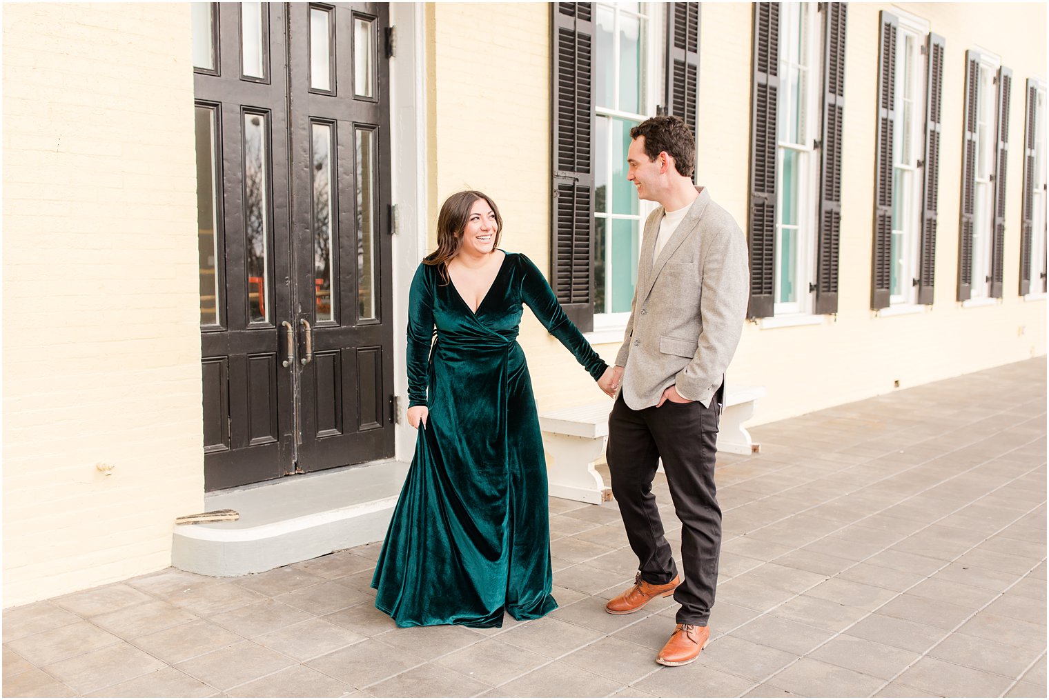 Bride wearing green velvet dress from Baltic Born holding fiance's hand 