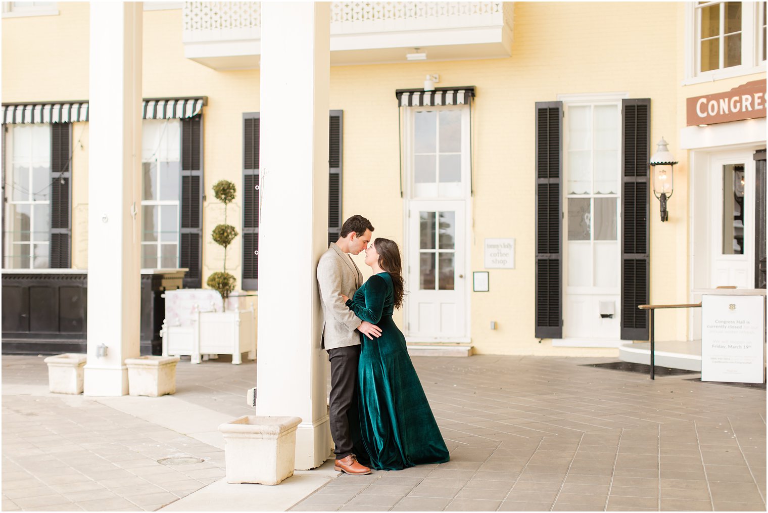 Couple holding each other in front of Congress Hall in Cape May for their engagement photos