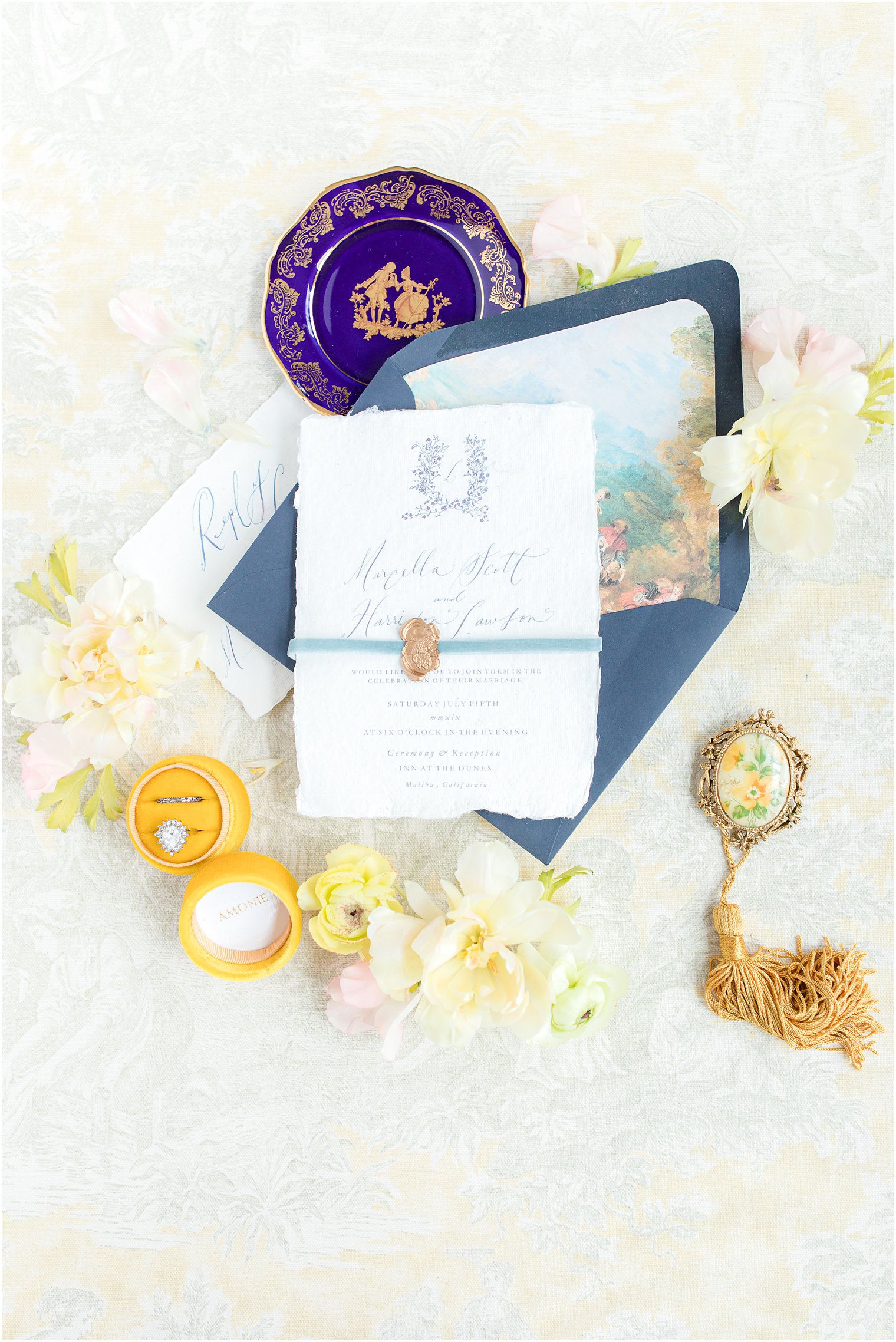 Invitation flatlay styled by Hazel Dust Studio includes navy envelope with envelope liner and mustard yellow ring box