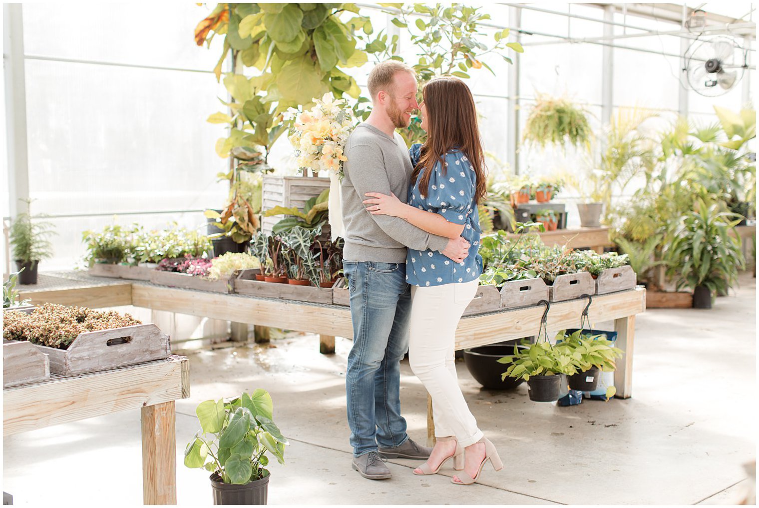 bride and groom stand nose to nose in greenhouse at Herbary at Bear Creek