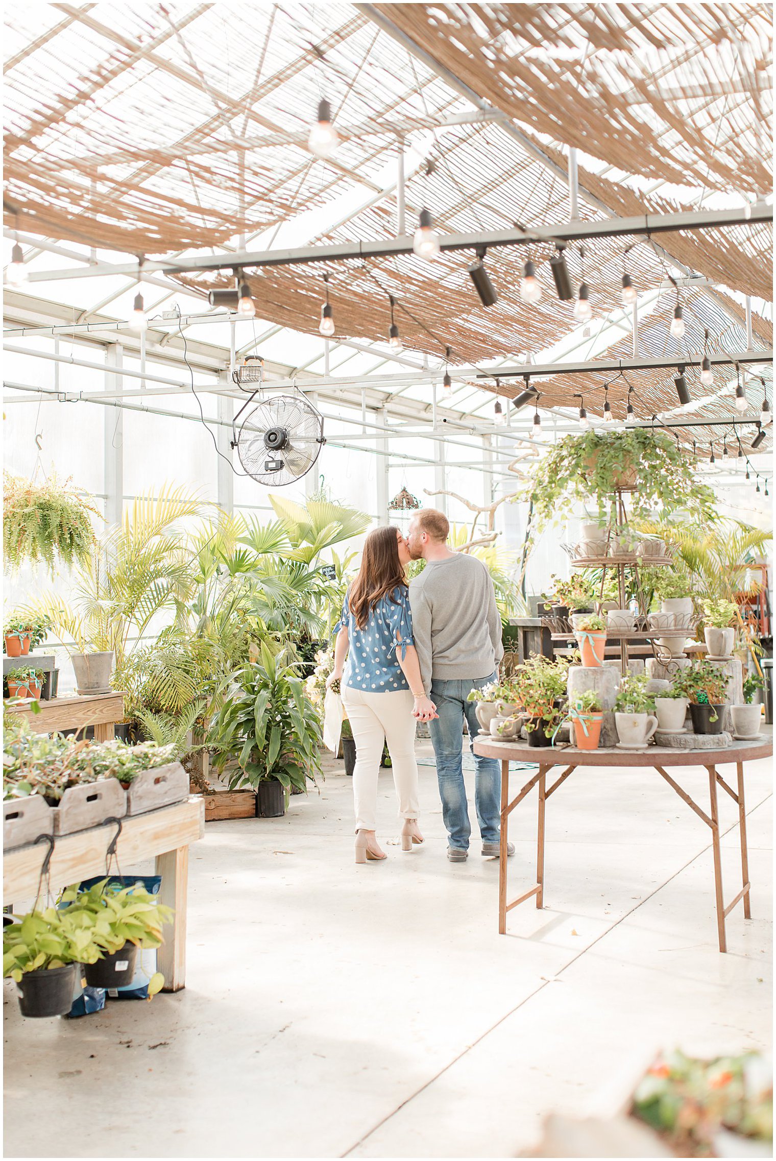 engaged couple kisses in Herbary at Bear Creek greenhouse