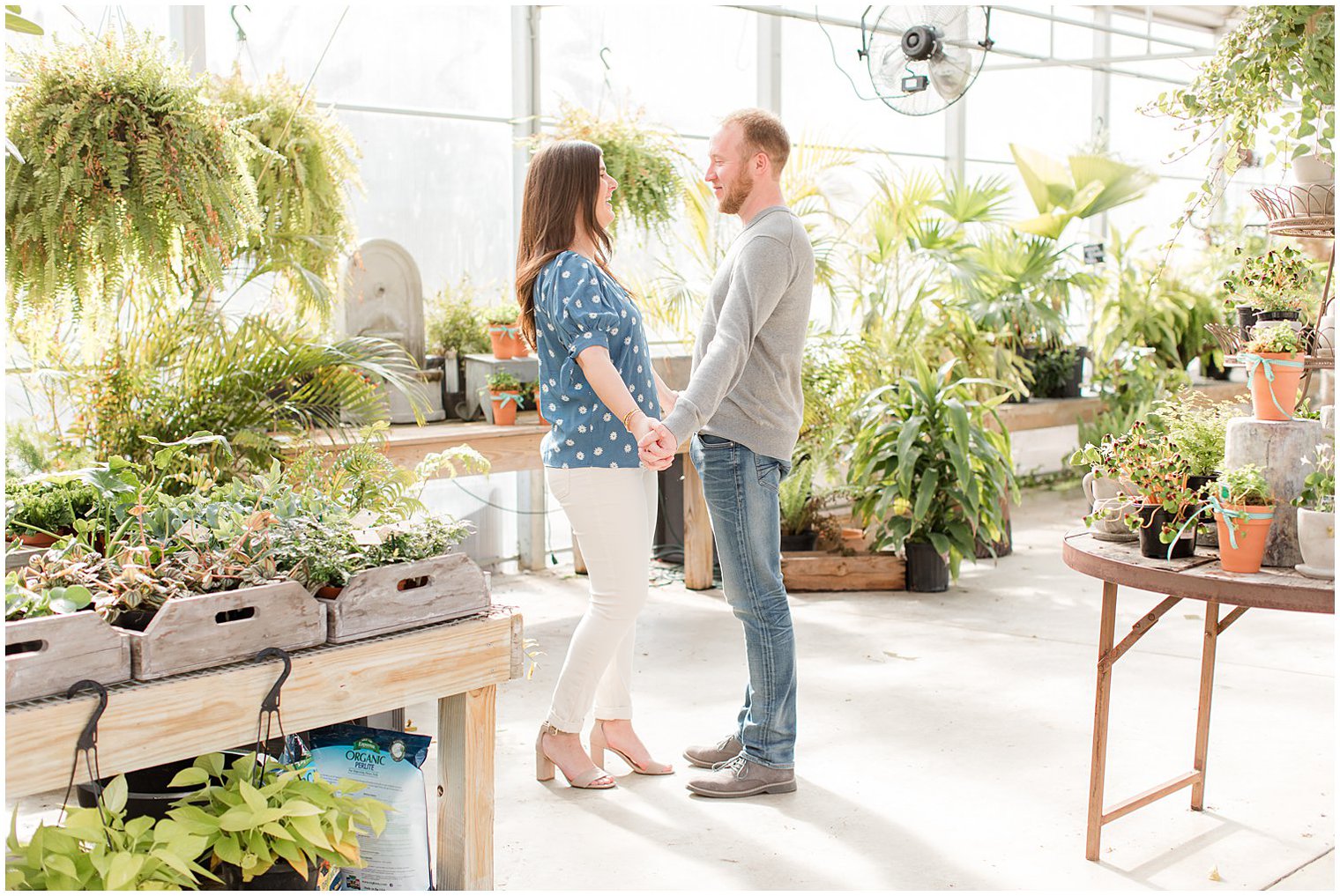 bride and groom hold hands standing in Monmouth NJ greenhouse 