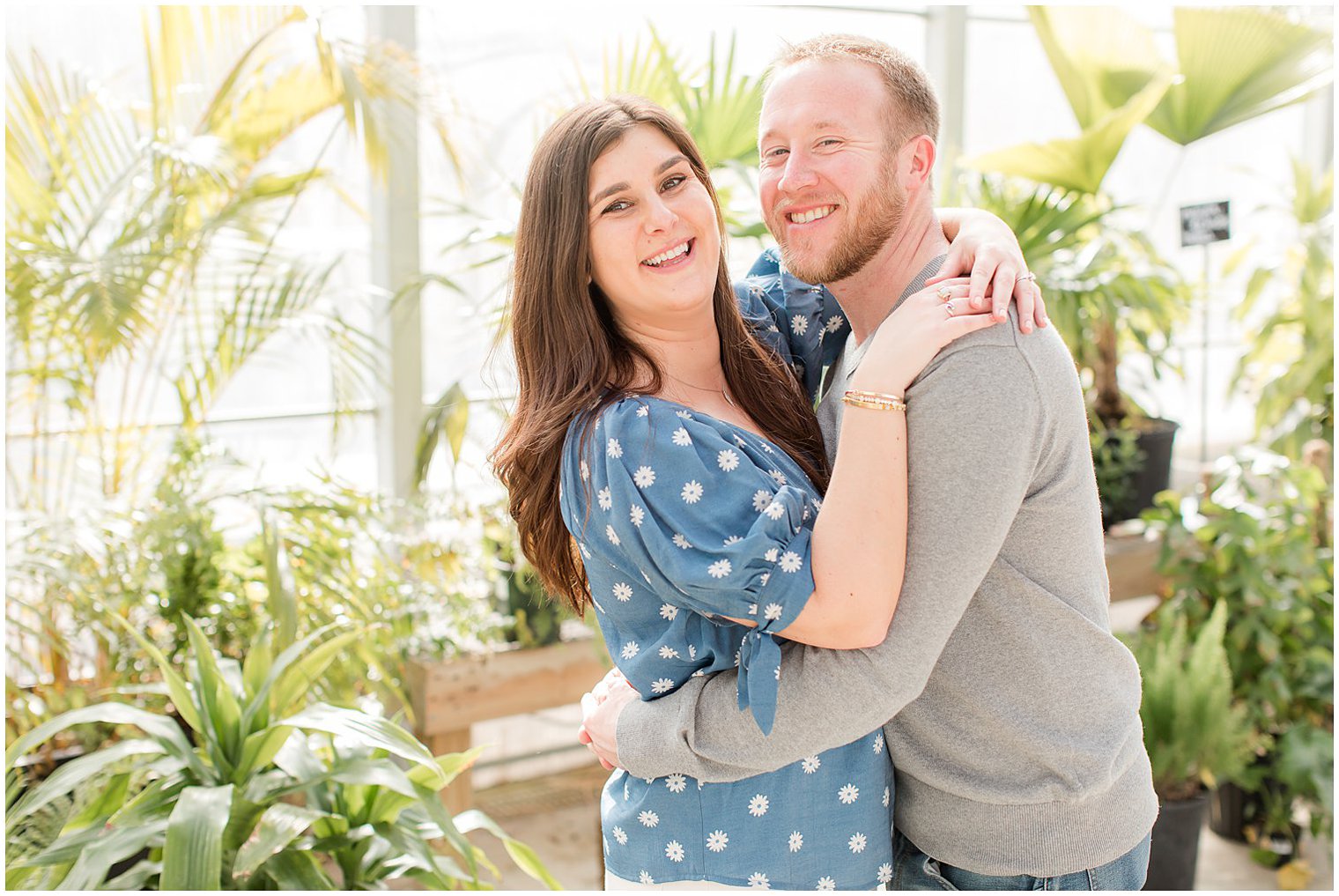 groom hugs bride during greenhouse engagement photos at Herbary at Bear Creek