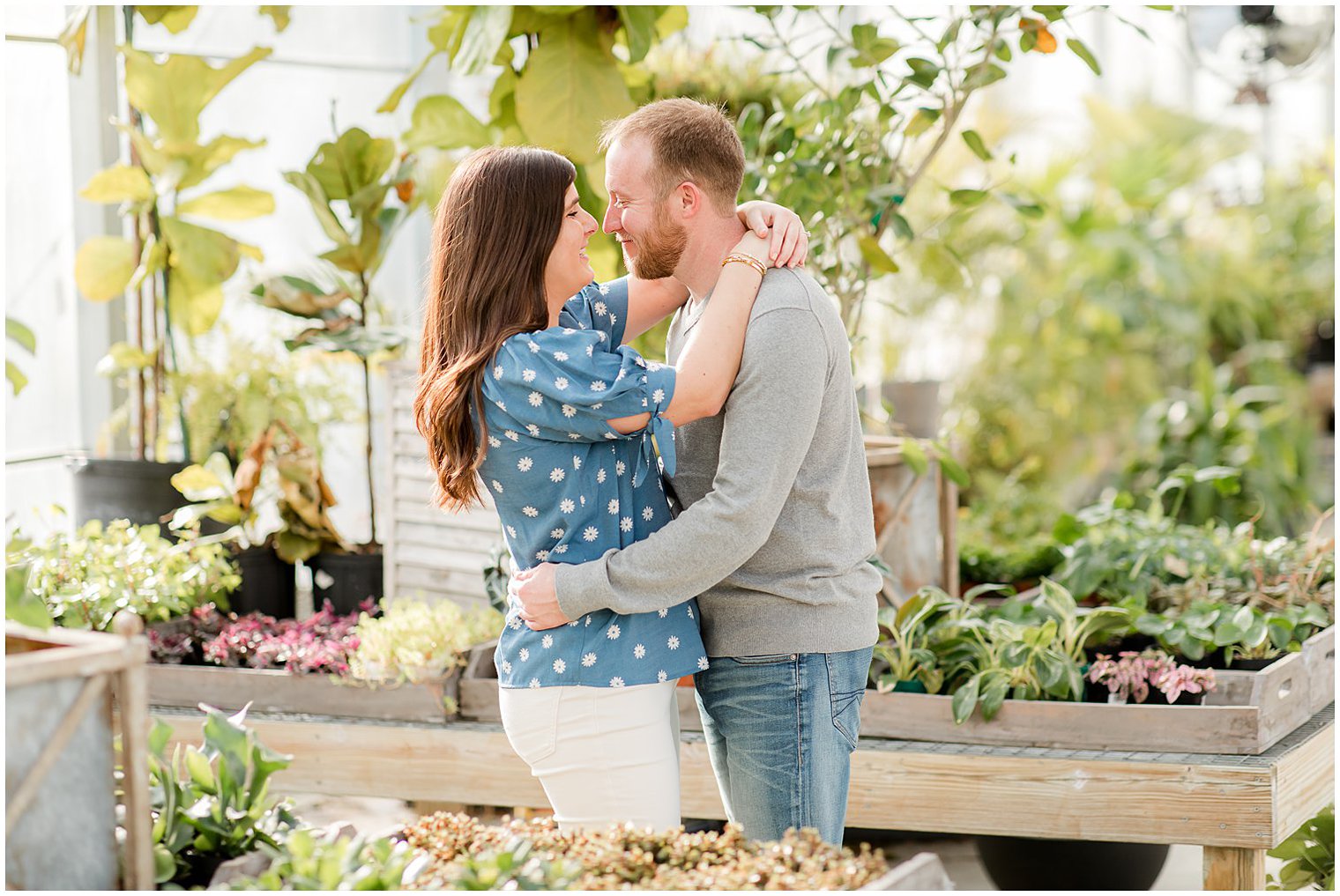 bride and groom touch noses standing between plants at Herbary at Bear Creek