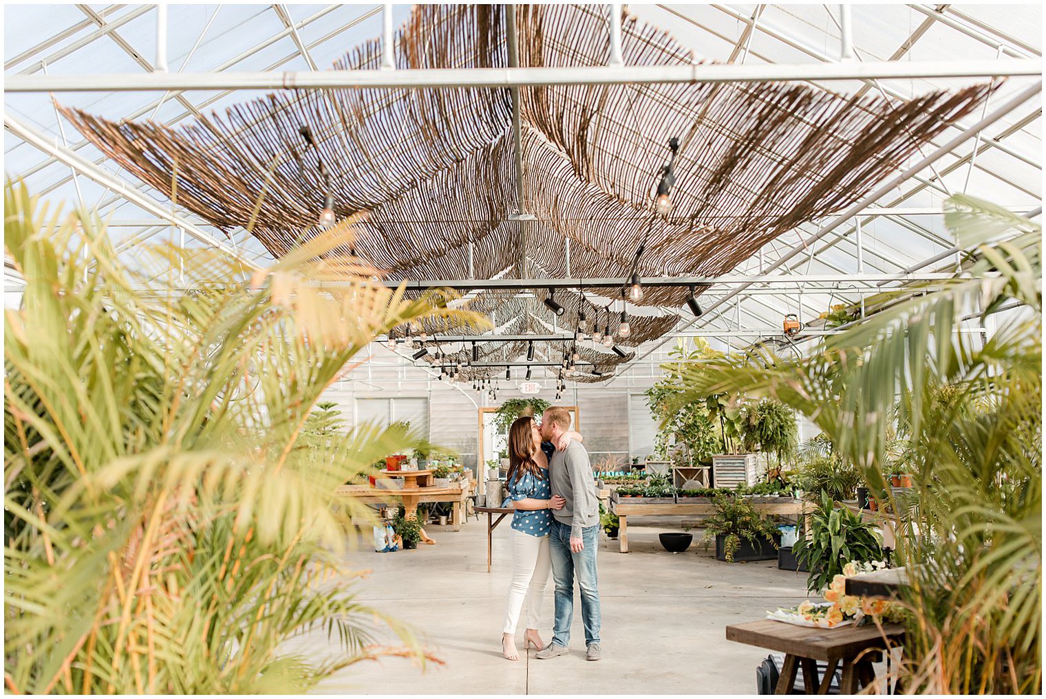 engaged couple kisses in New Jersey greenhouse during engagement session