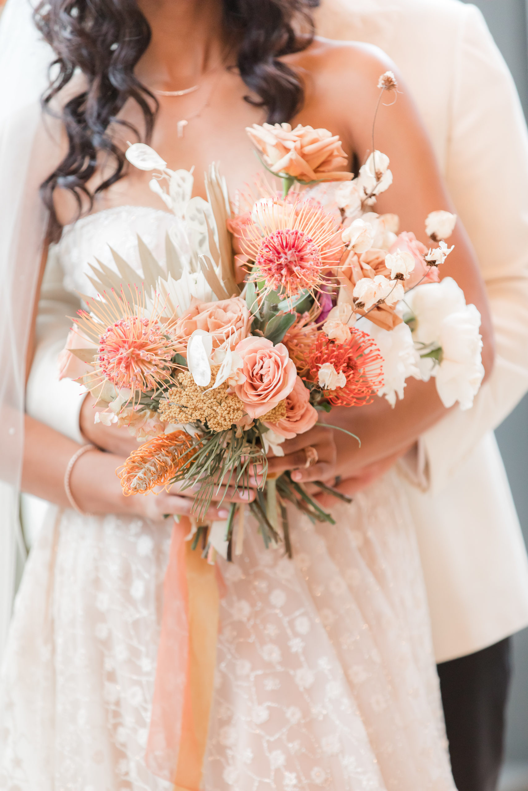 bride holds bouquet of pink and peach florals for Philadelphia wedding