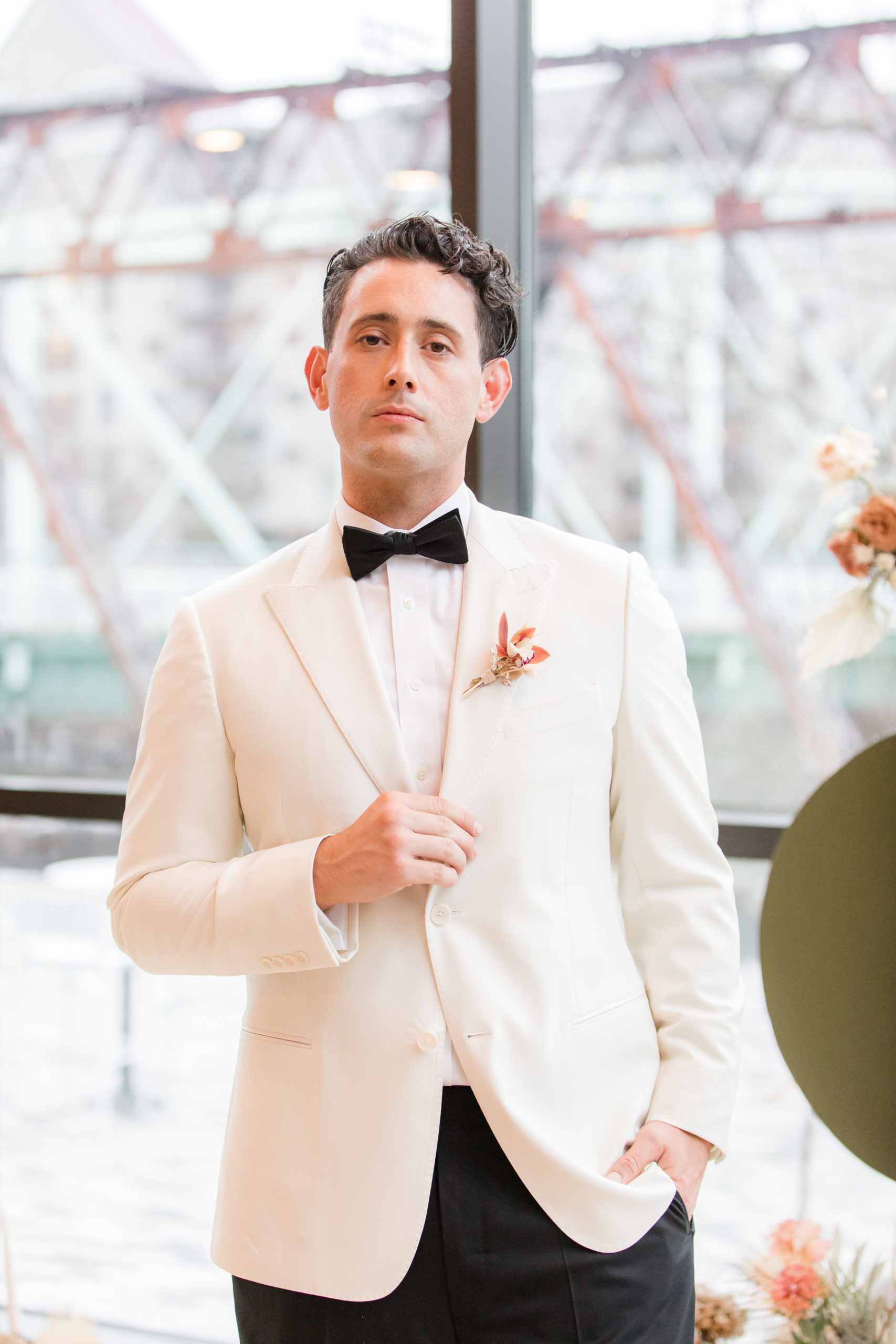 groom in a white tux jacket poses during Philadelphia PA styled shoot 