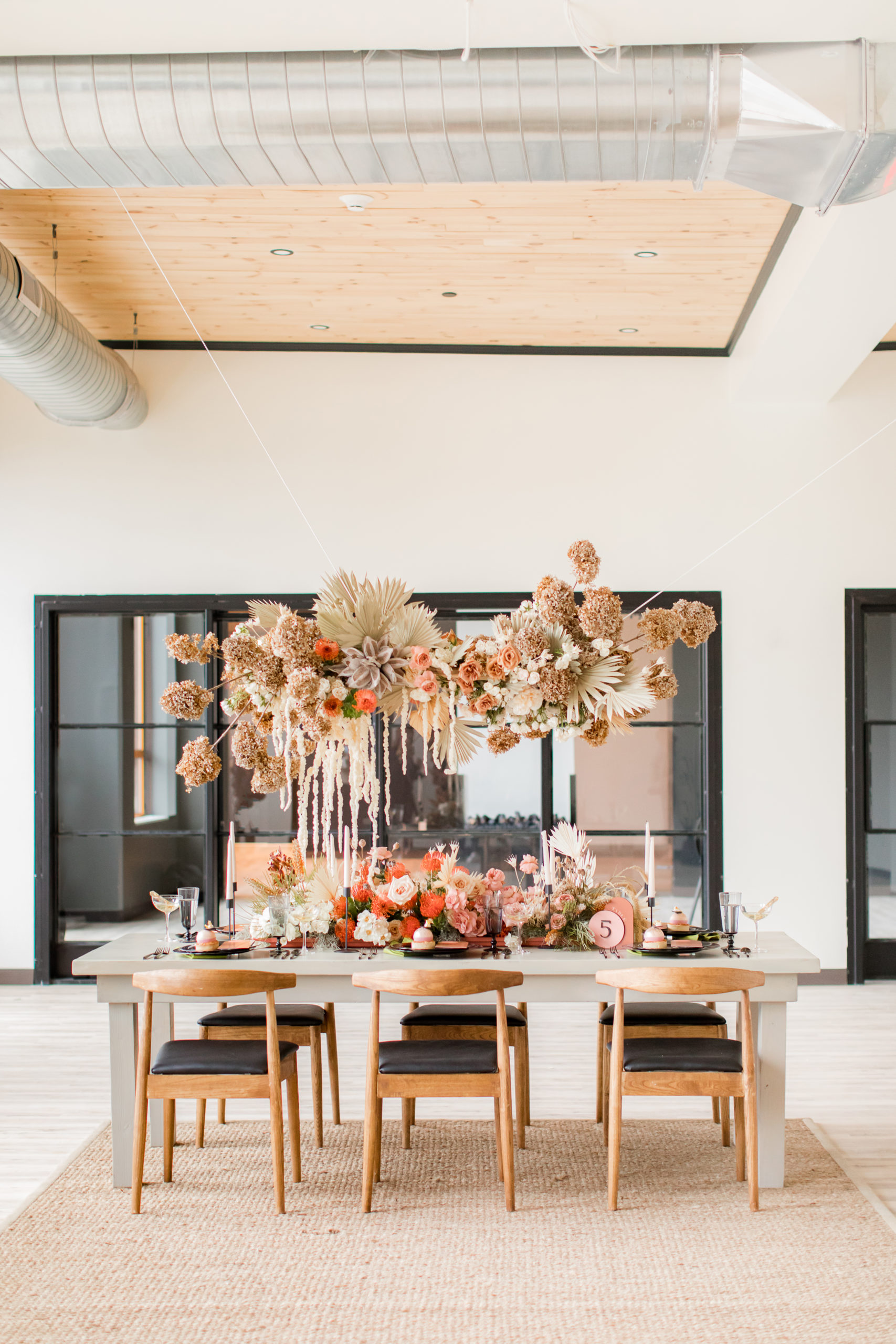 wedding reception with hanging floral display containing muted brown and pink florals 