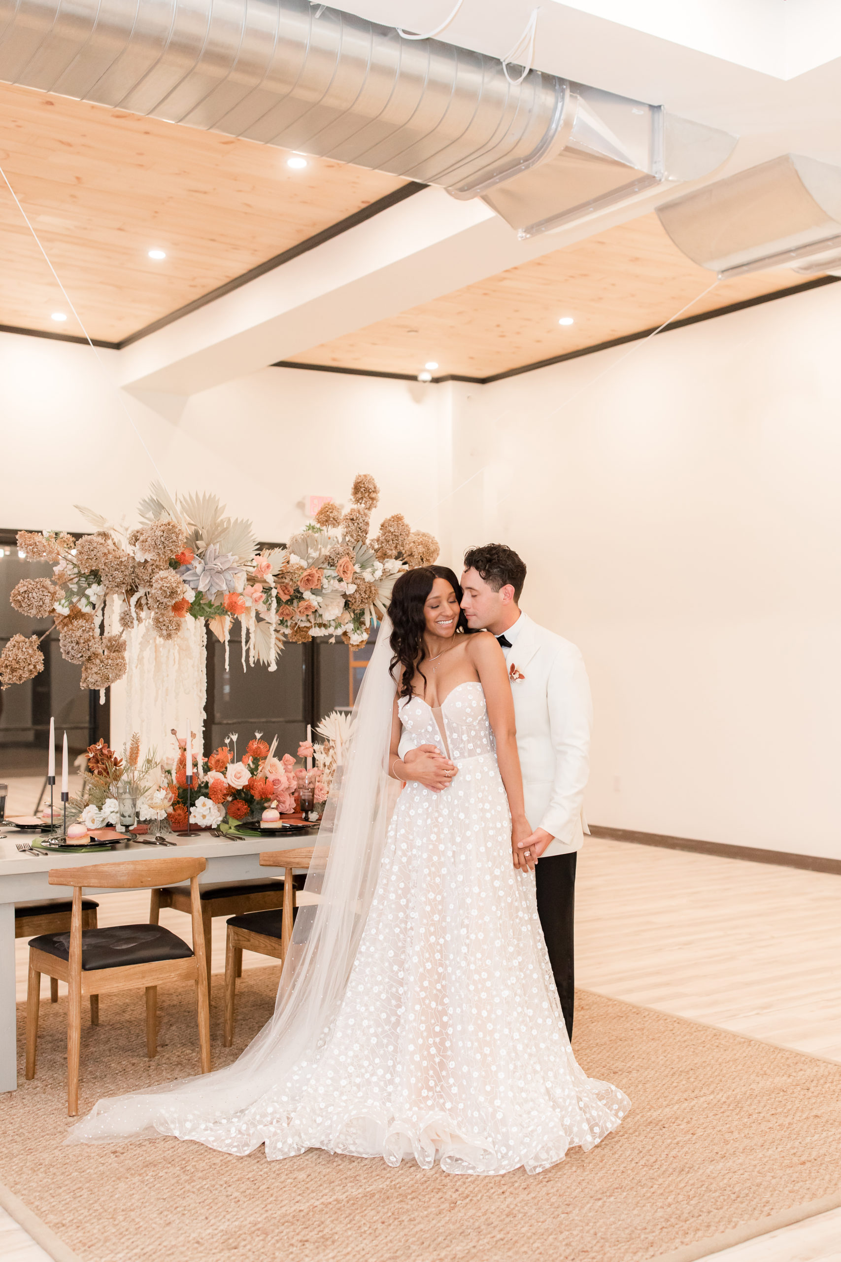 bride and groom pose by dinner table at citrus inspired styled shoot 