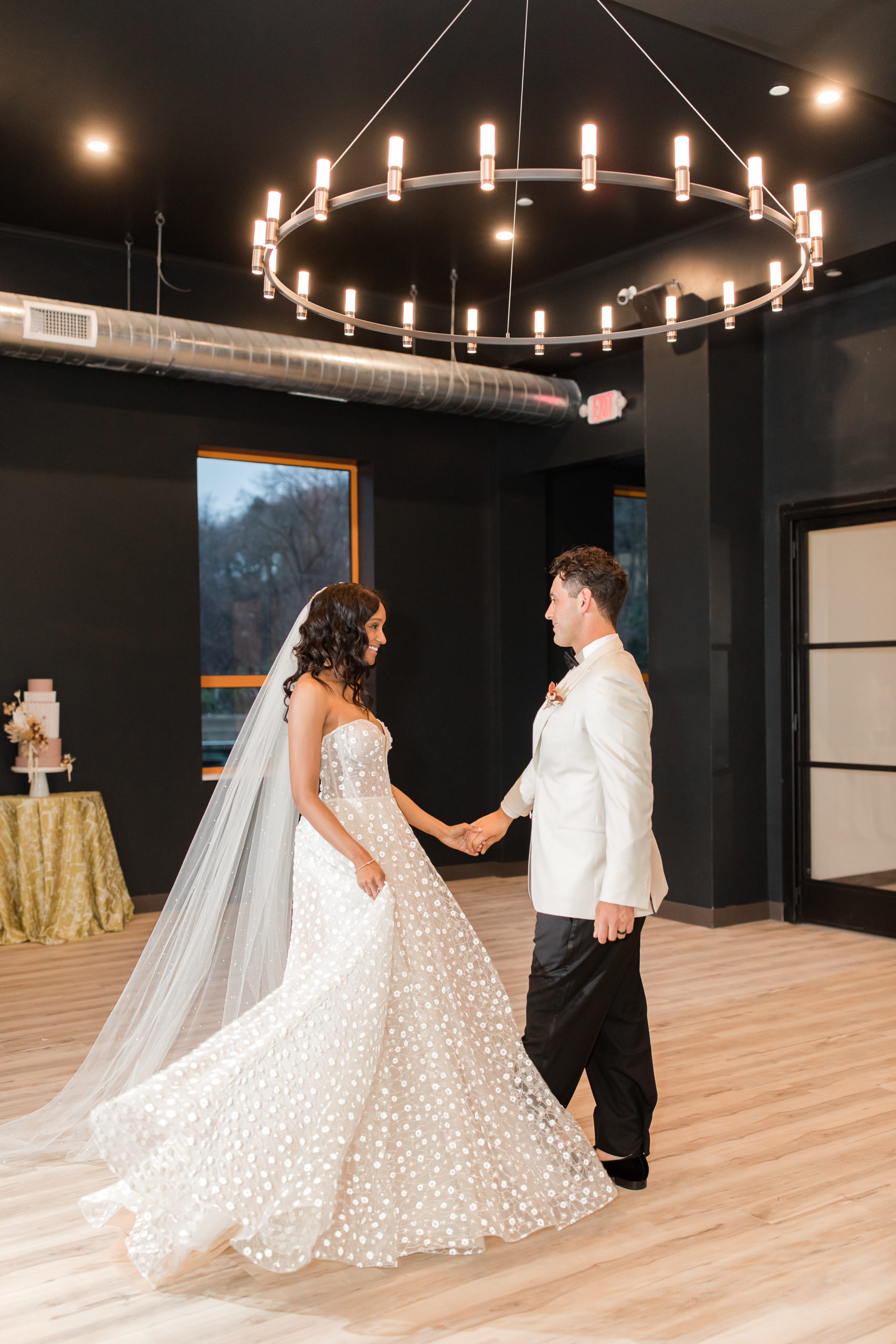 bride and groom dance under chandelier at Ironworks at Pencoyd Landing